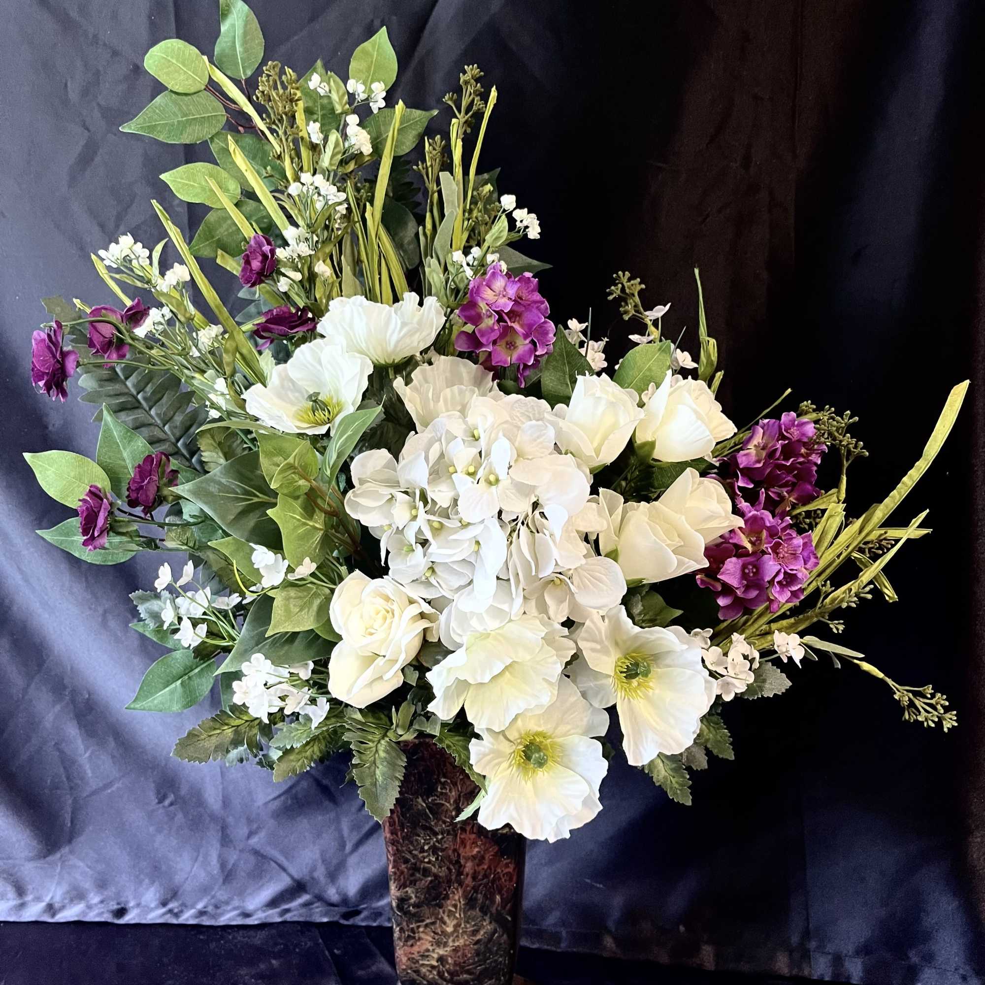 A concentrated cloud of crisp white blooms-hydrangeas and anemone-like flowers-forms the heart