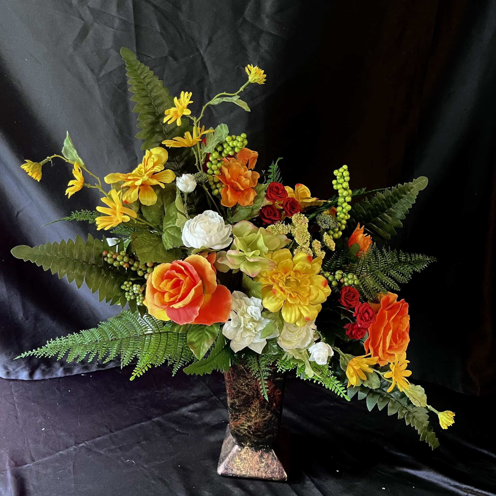 Vibrant orange roses and sunny yellow daisies create an immediate burst of