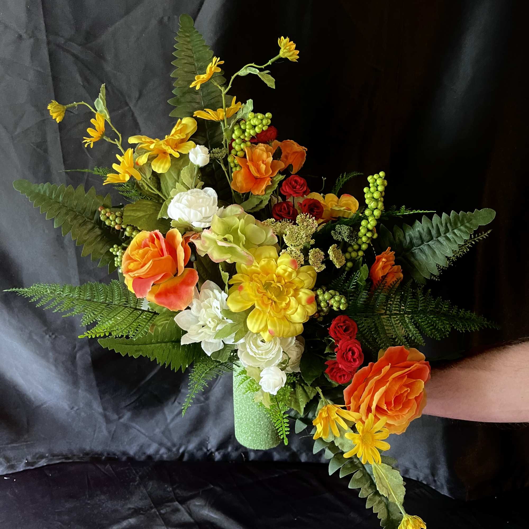 Vibrant orange roses and sunny yellow daisies create an immediate burst of