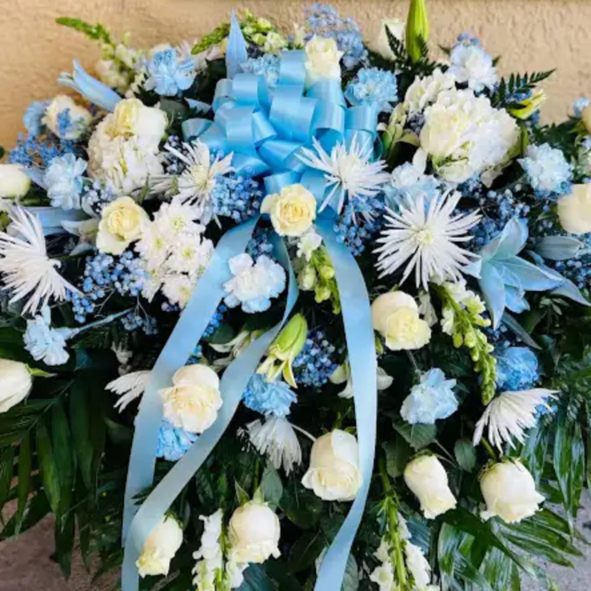 Baby blue & white sympathy casket Sprayby Alcatraz Flower Shop