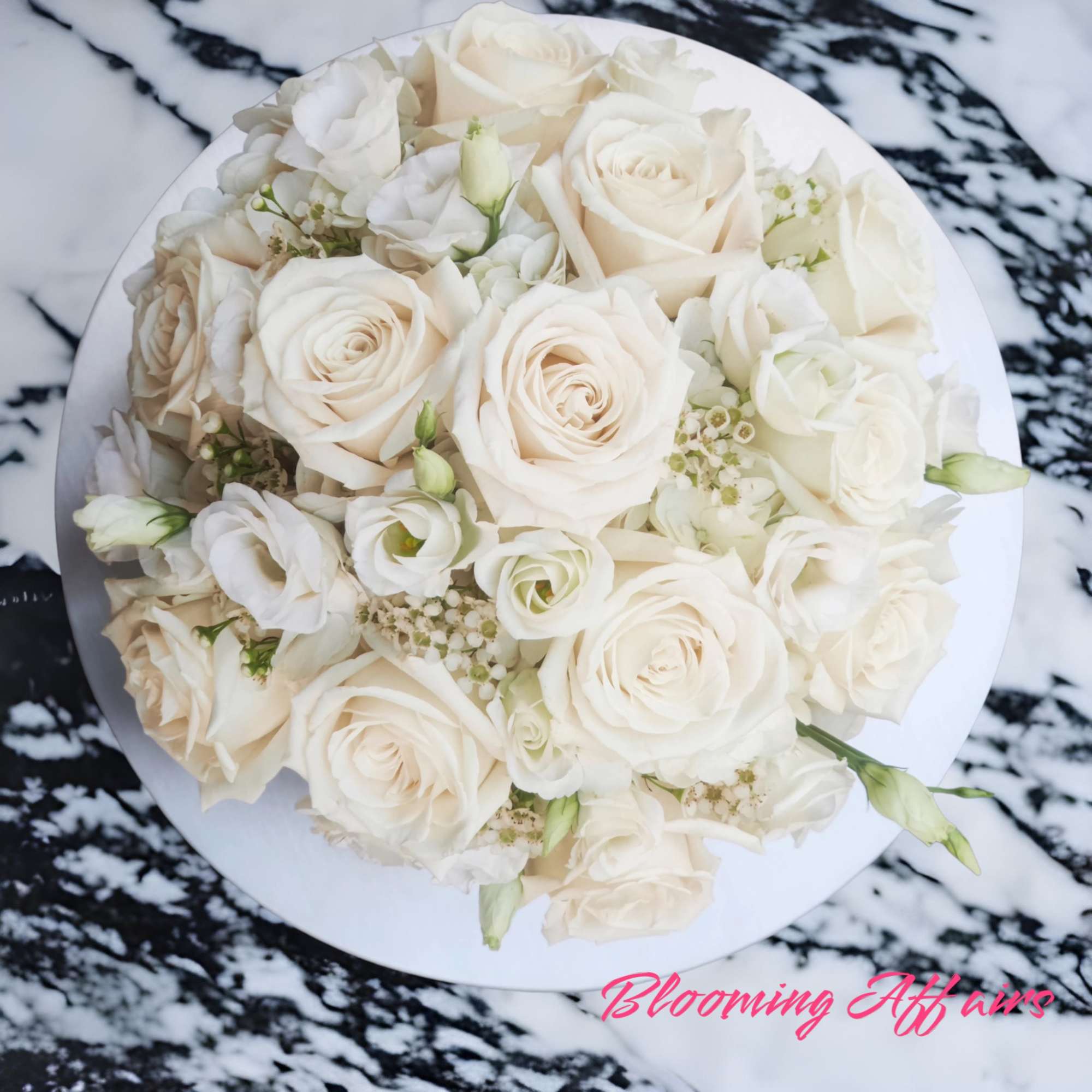 Round bouquet of white roses and small white blooms