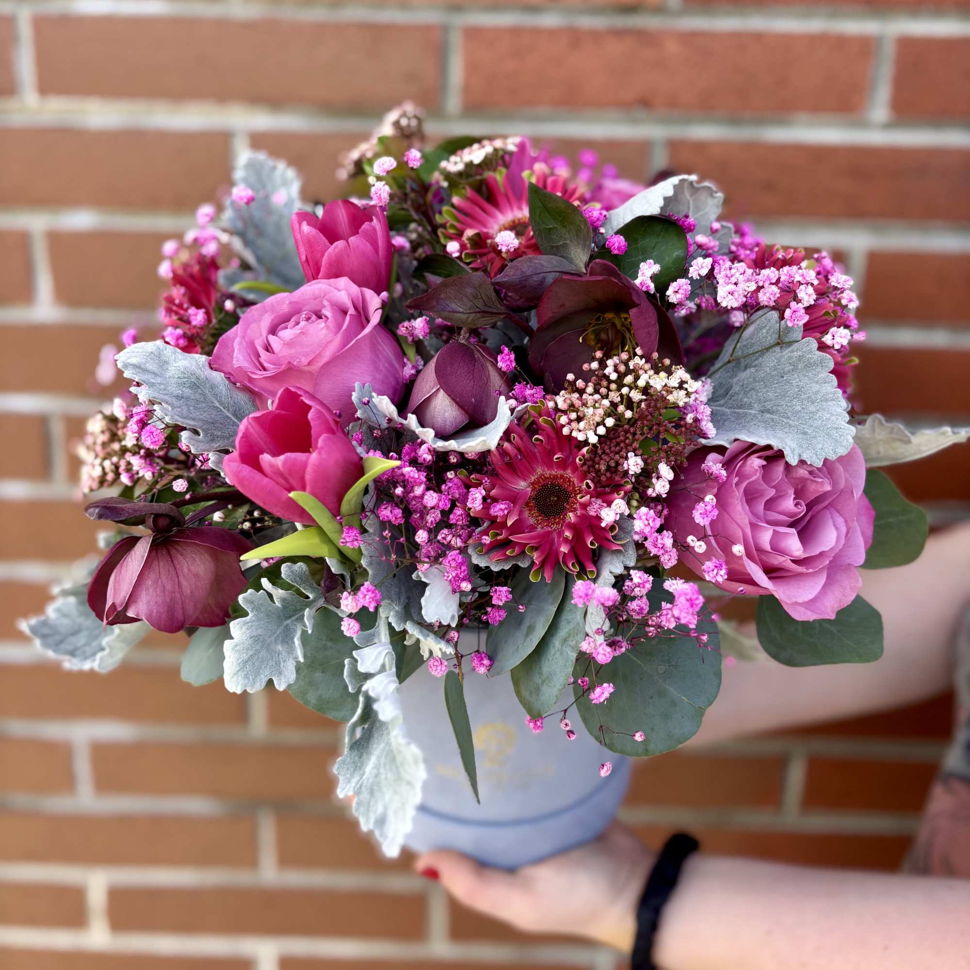 Pink and purple bouquet in a pale vase