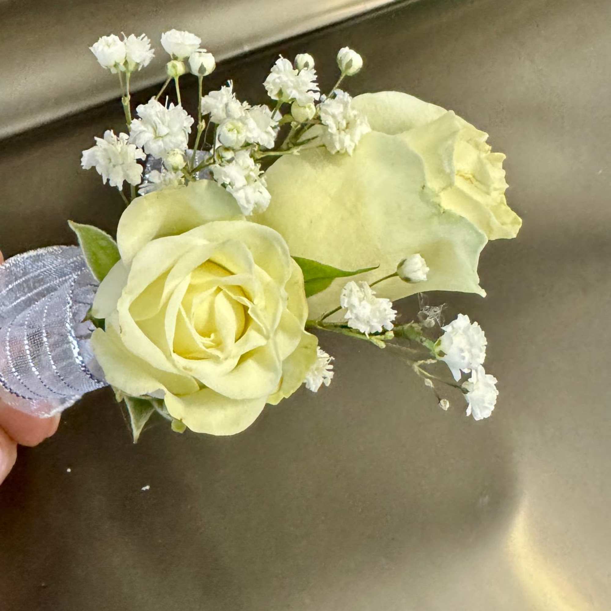 Small boutonniere with pale yellow roses and white filler flowers