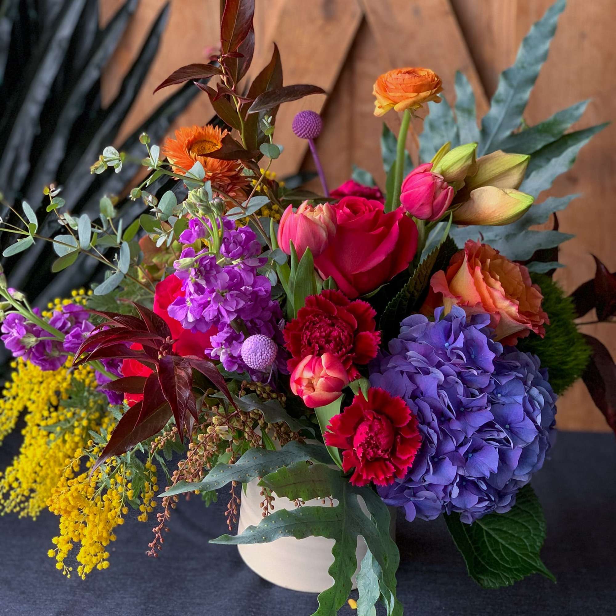 Colorful mixed flower arrangement in a white vase