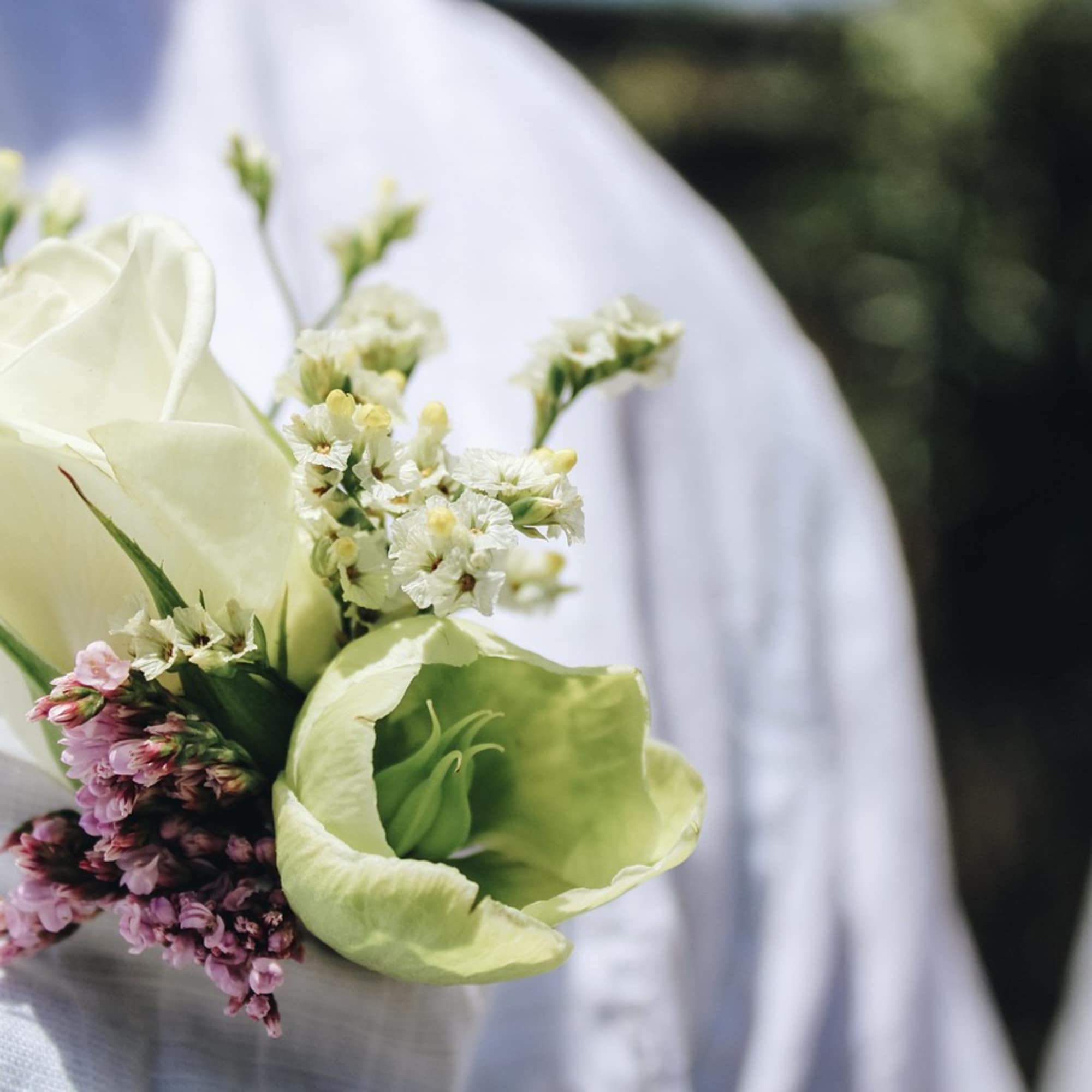 Small boutonniere with white roses and pale green flowers
