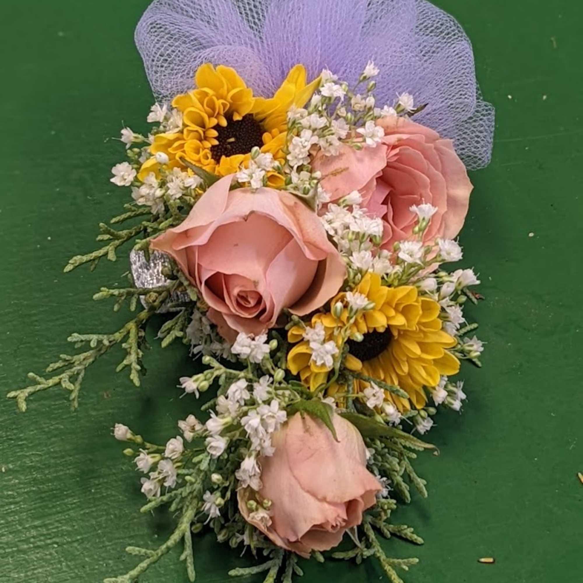 Small floral corsage with pink roses and yellow daisies on purple netting