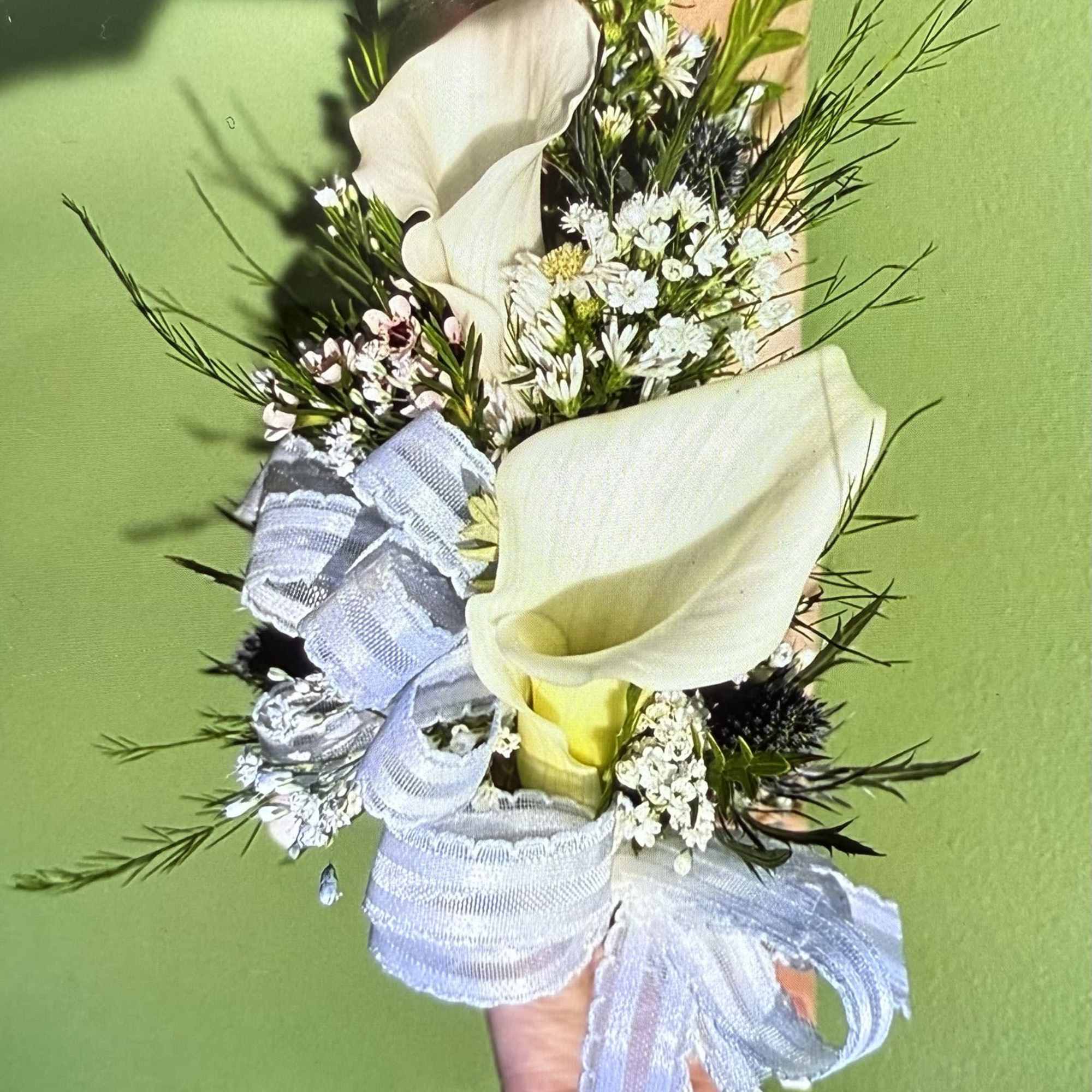 Handheld bouquet with white calla lilies and small white flowers