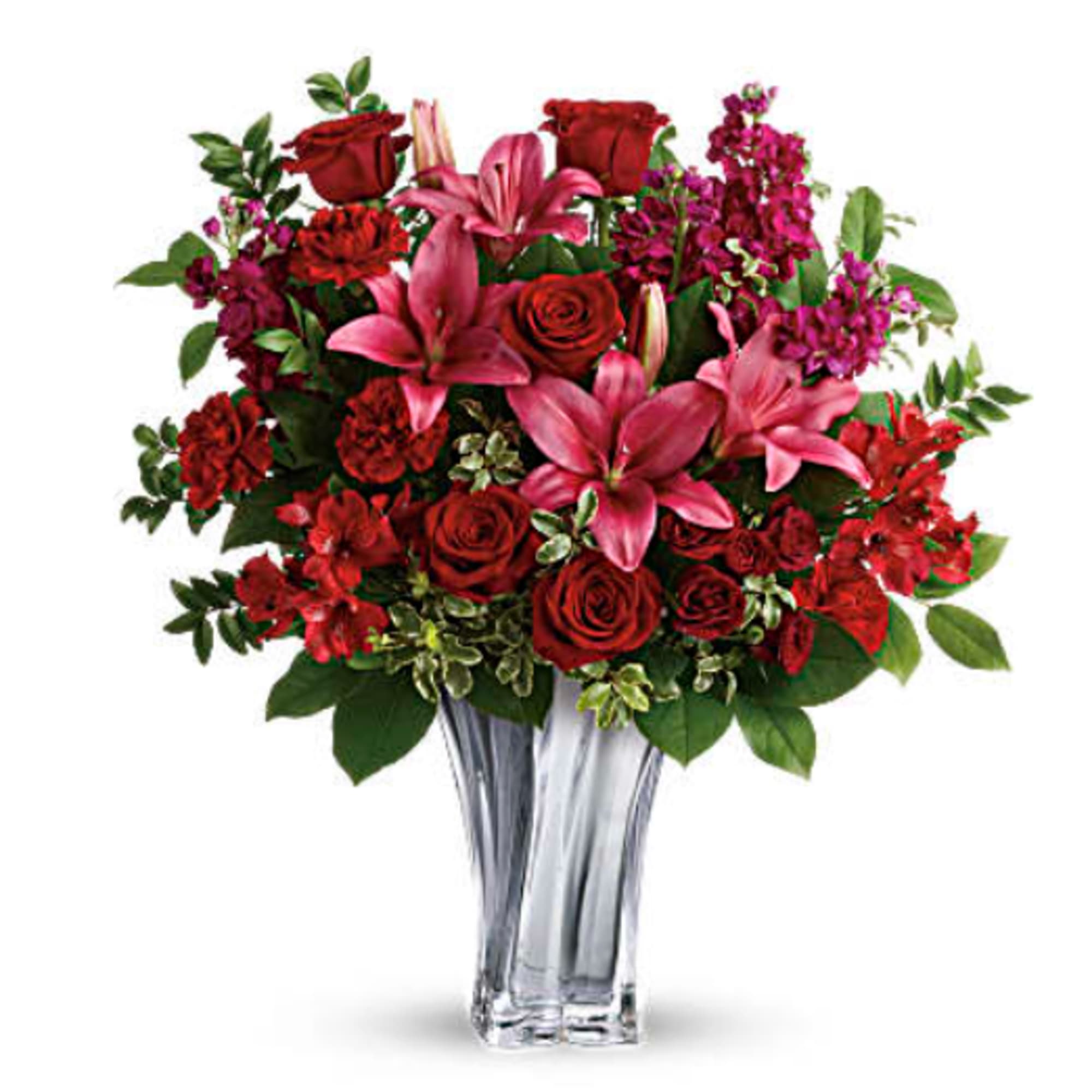 Red roses and pink lilies in a clear glass vase