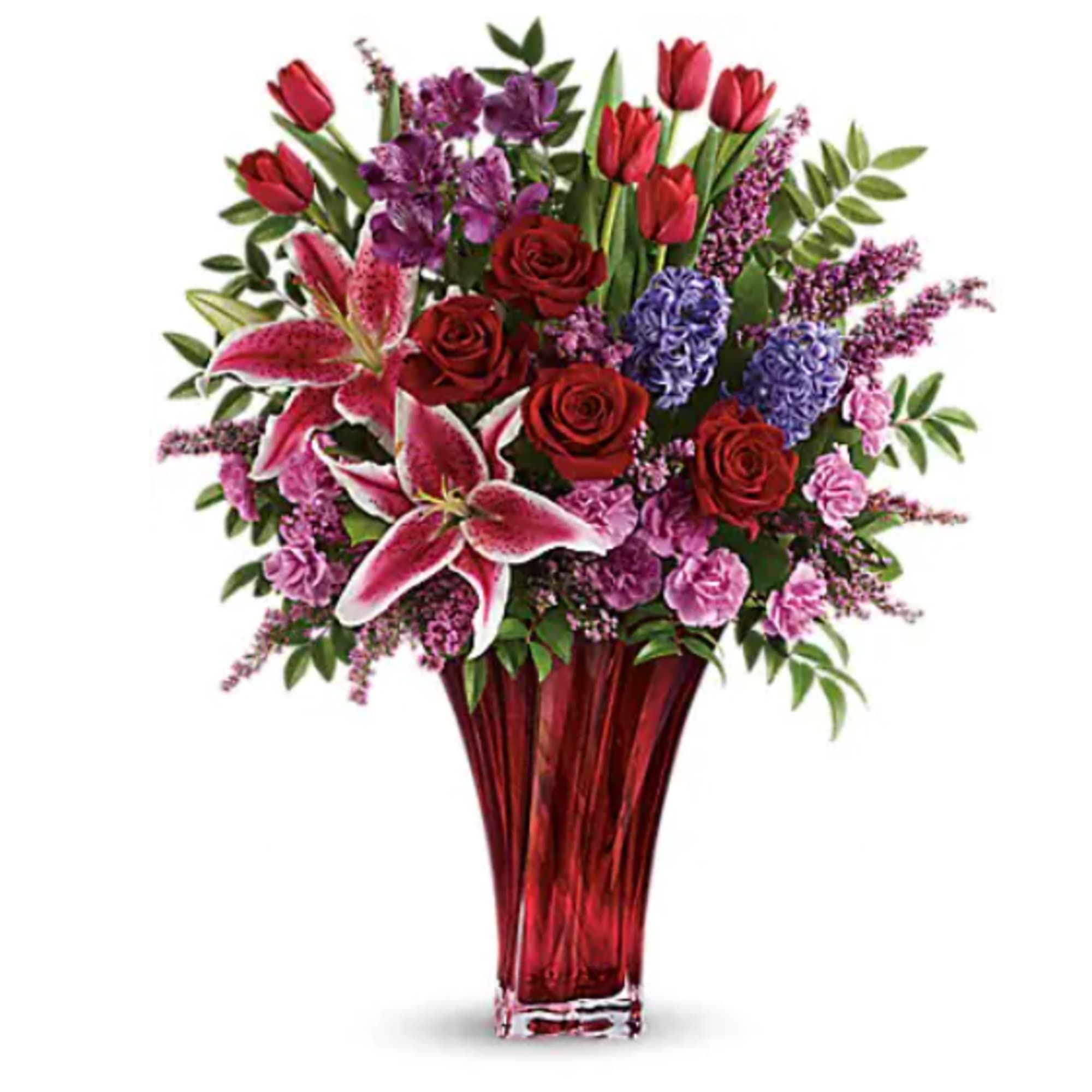 Mixed bouquet in a red glass vase with roses, lilies, tulips, and purple blooms