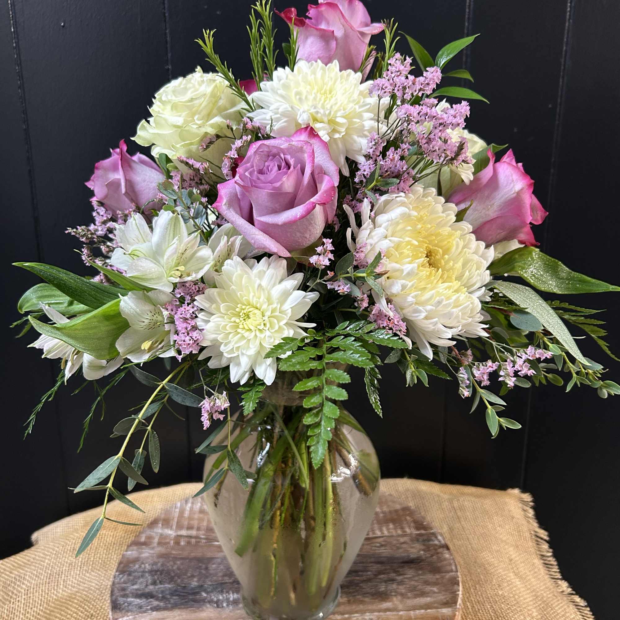 Beautiful mix of purple and white flowers including roses, cremons, alstromeria, etc.
