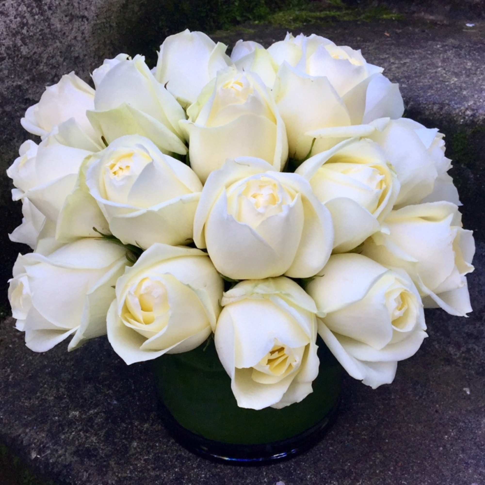 Bouquet of white roses in a dark glass vase