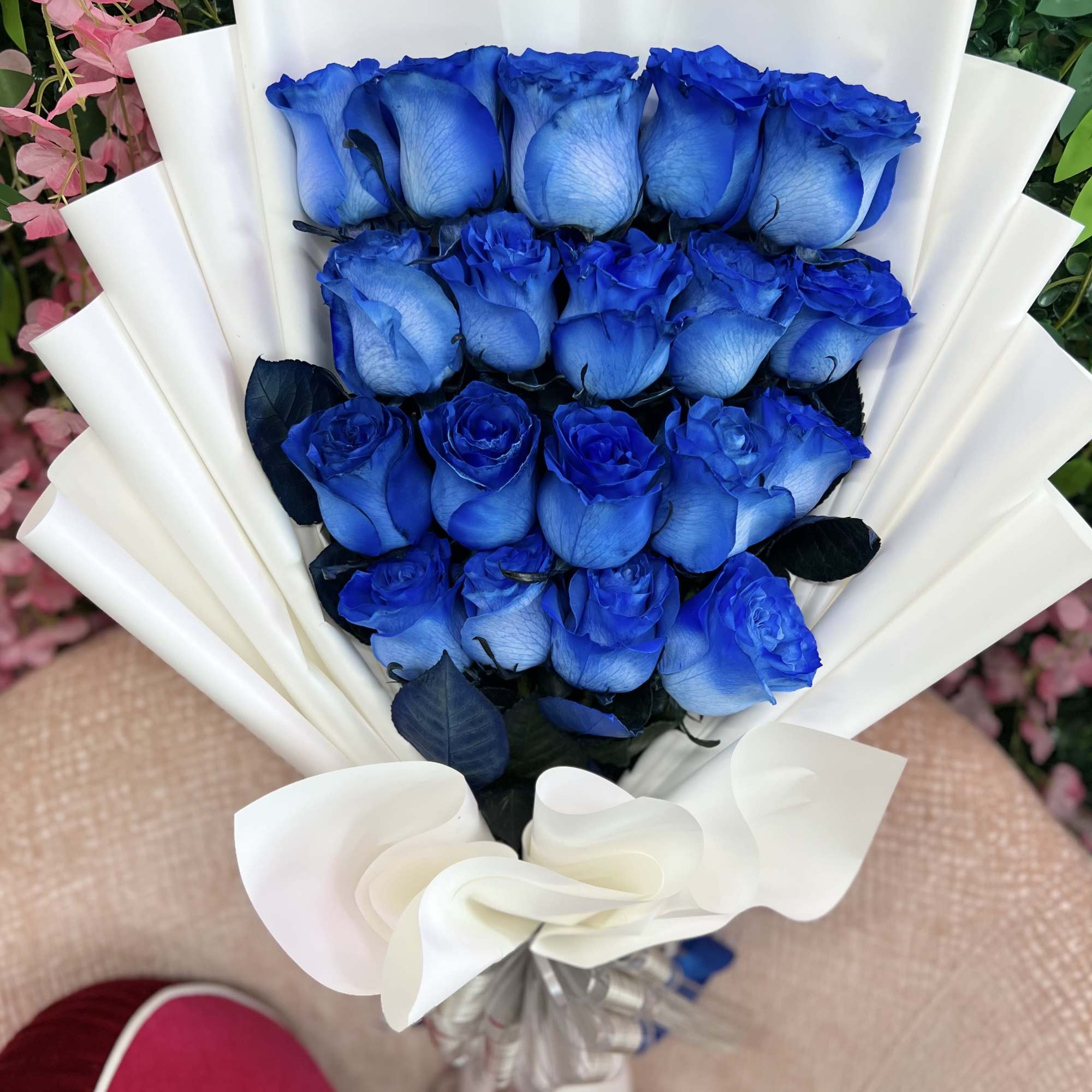 A captivating arrangement of fresh blue roses, elegantly wrapped and tied with