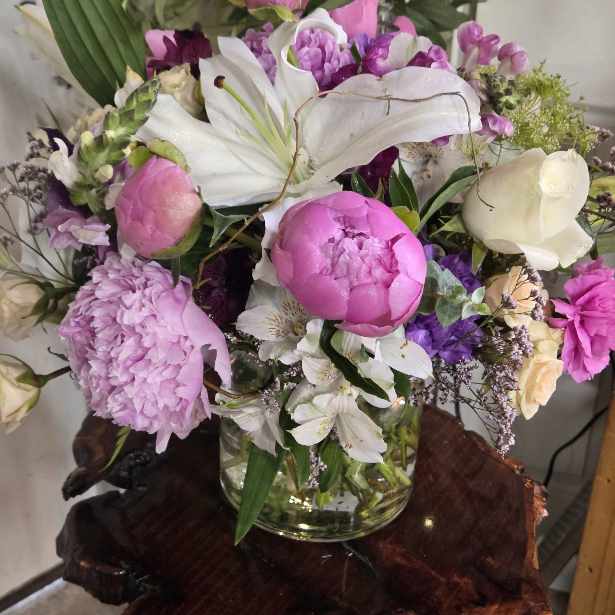 True peonies, elegant lilies, roses, and premium seasonal blooms gathered into a