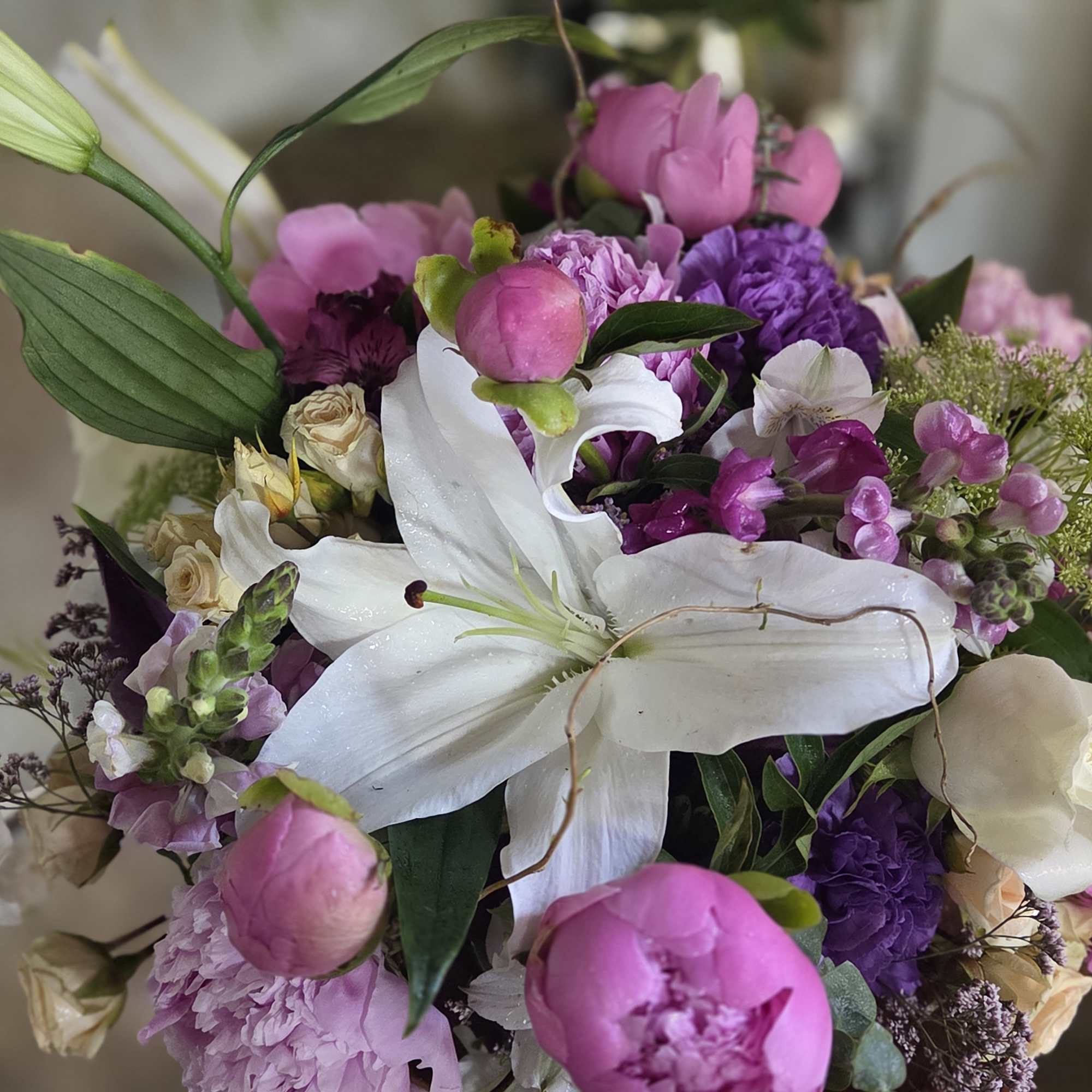 True peonies, elegant lilies, roses, and premium seasonal blooms gathered into a
