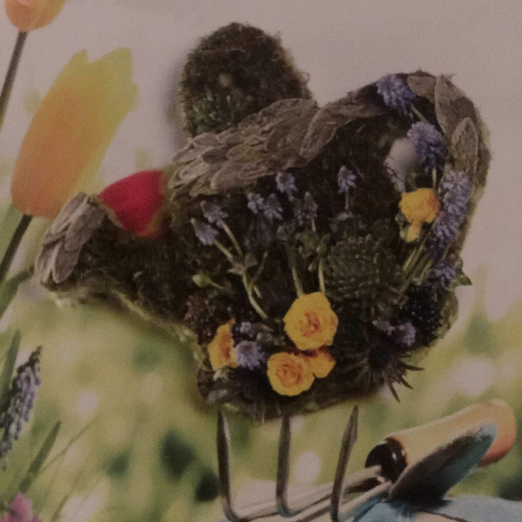 Small floral arrangement with yellow and purple blooms in a decorative holder