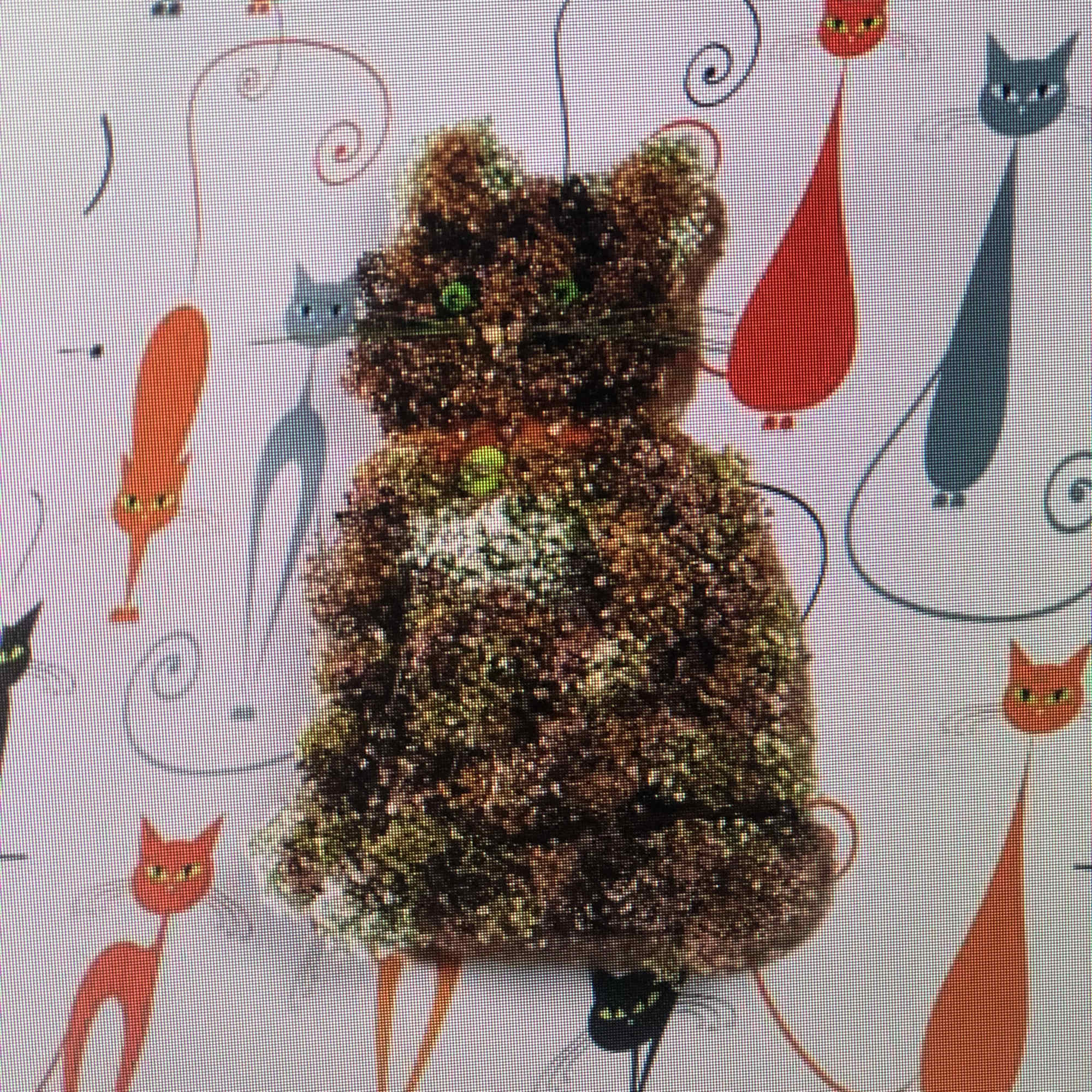 Cat-shaped glitter decoration with green eyes on a patterned background