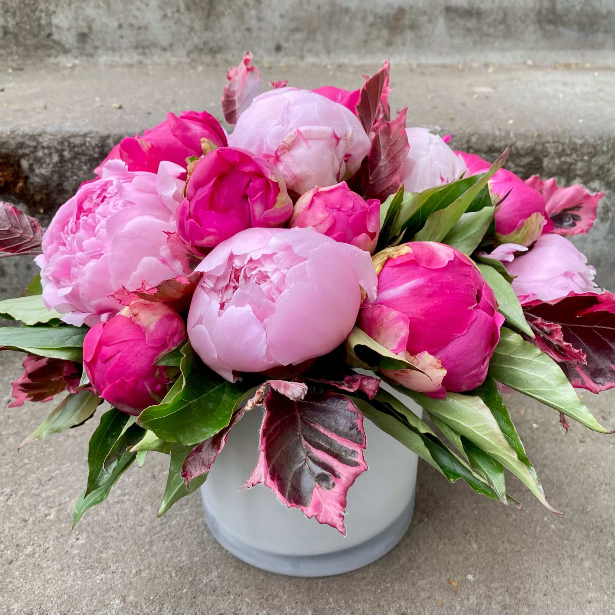 Pink peony bouquet in a white vase