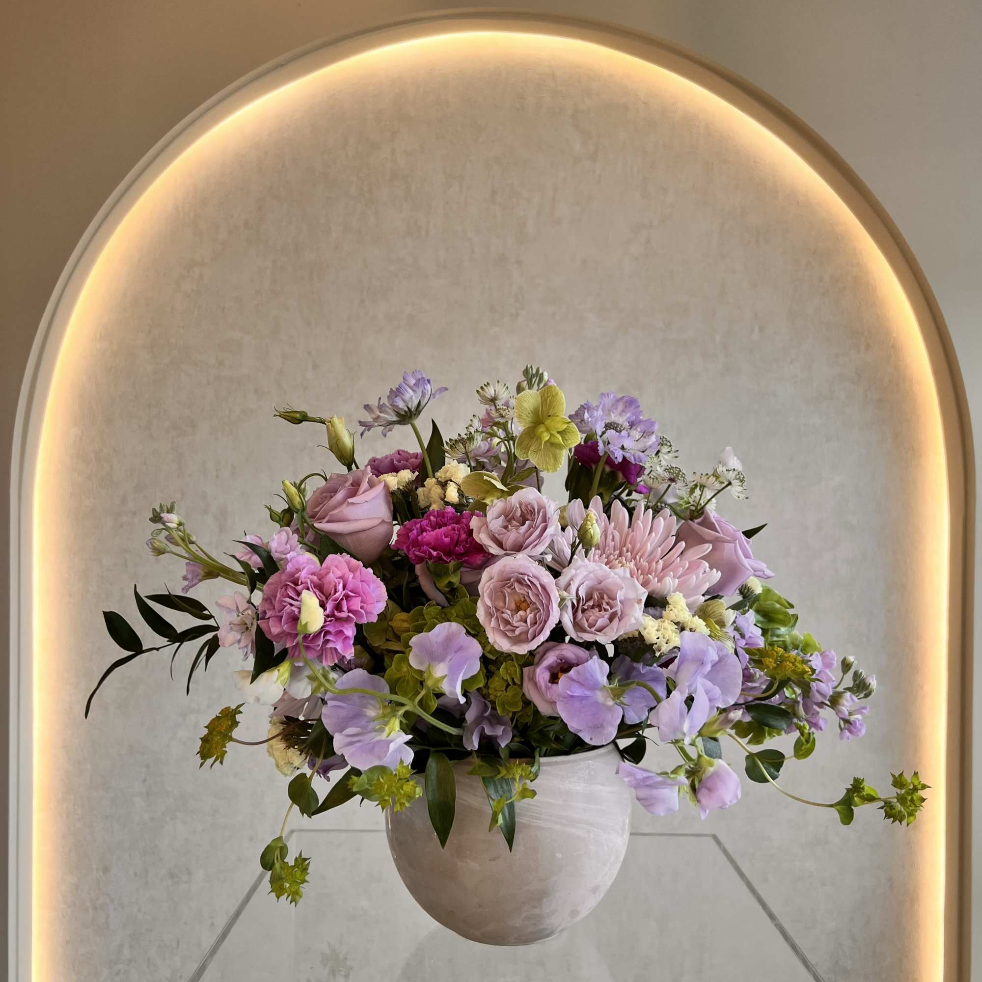 Full rounded mix of roses, carnations, lisianthus in pink, lavender and white