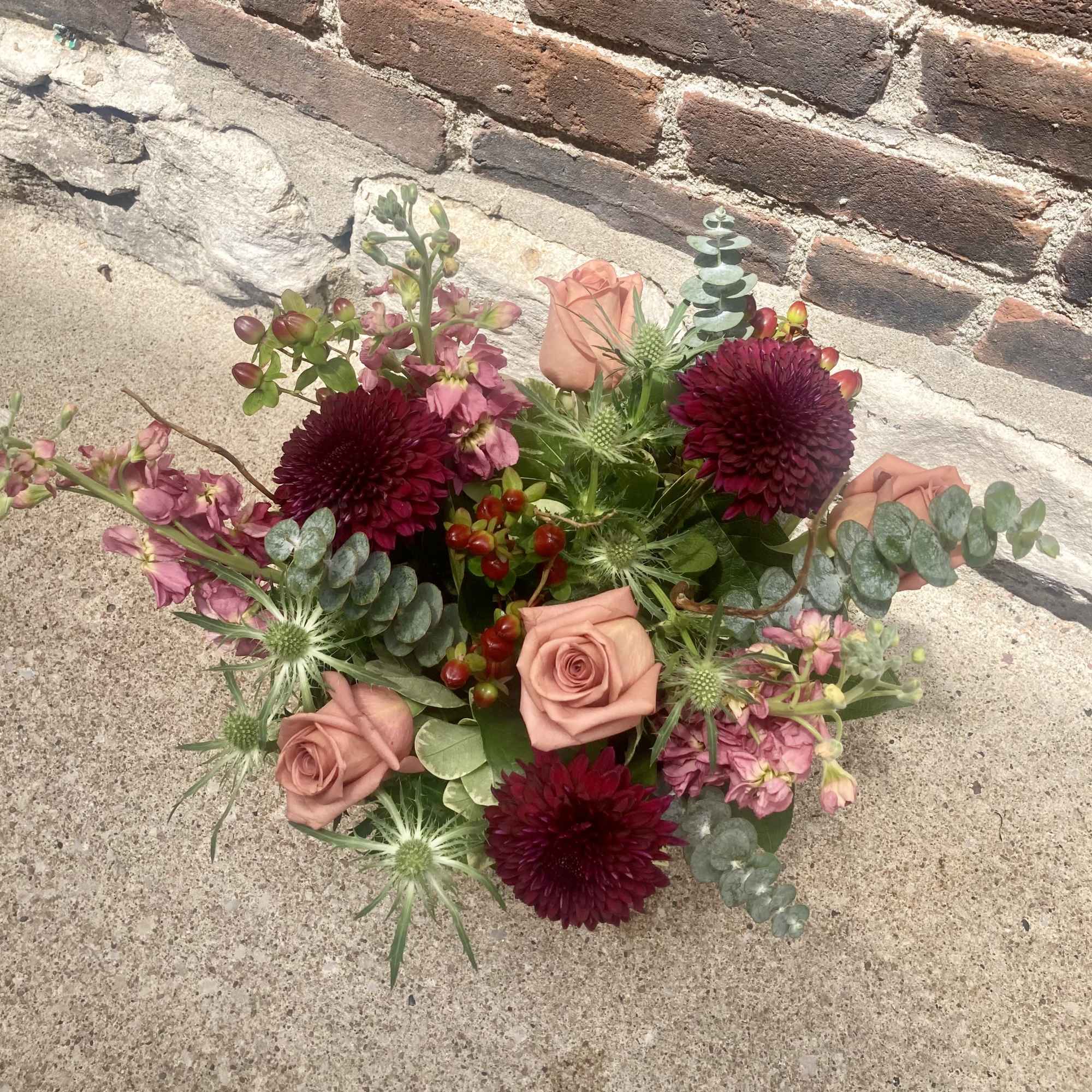 Toffee colored roses paired with deep burgundy chrysanthemums give this flower arrangement