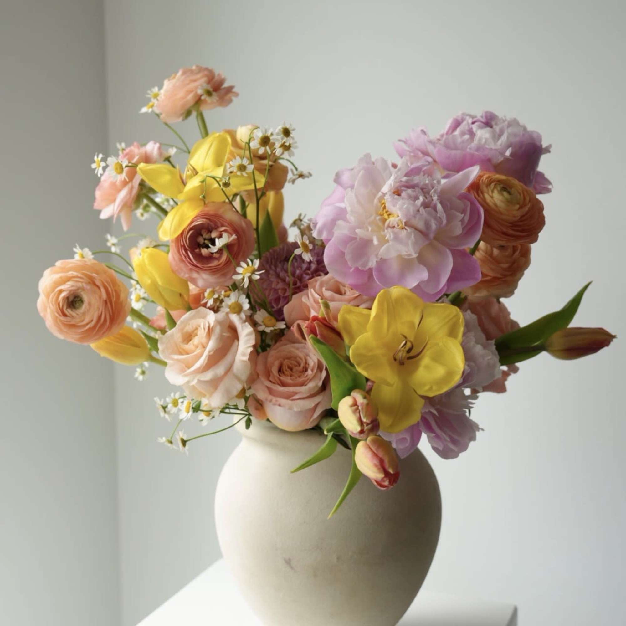 A vibrant spring arrangement designed to bring instant joy. Featuring tulips, ranunculus