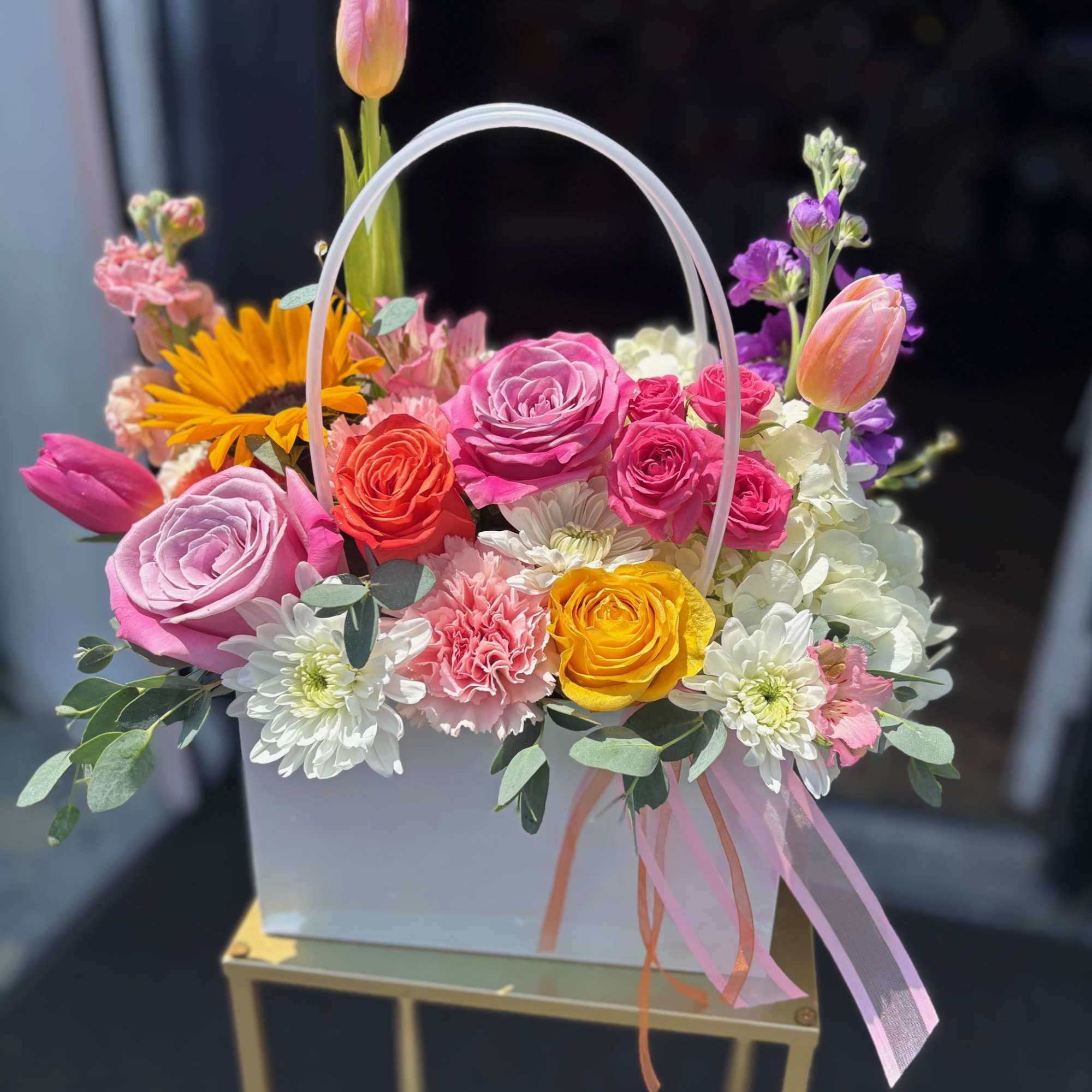 Colorful mixed flower basket with roses, tulips, and daisies