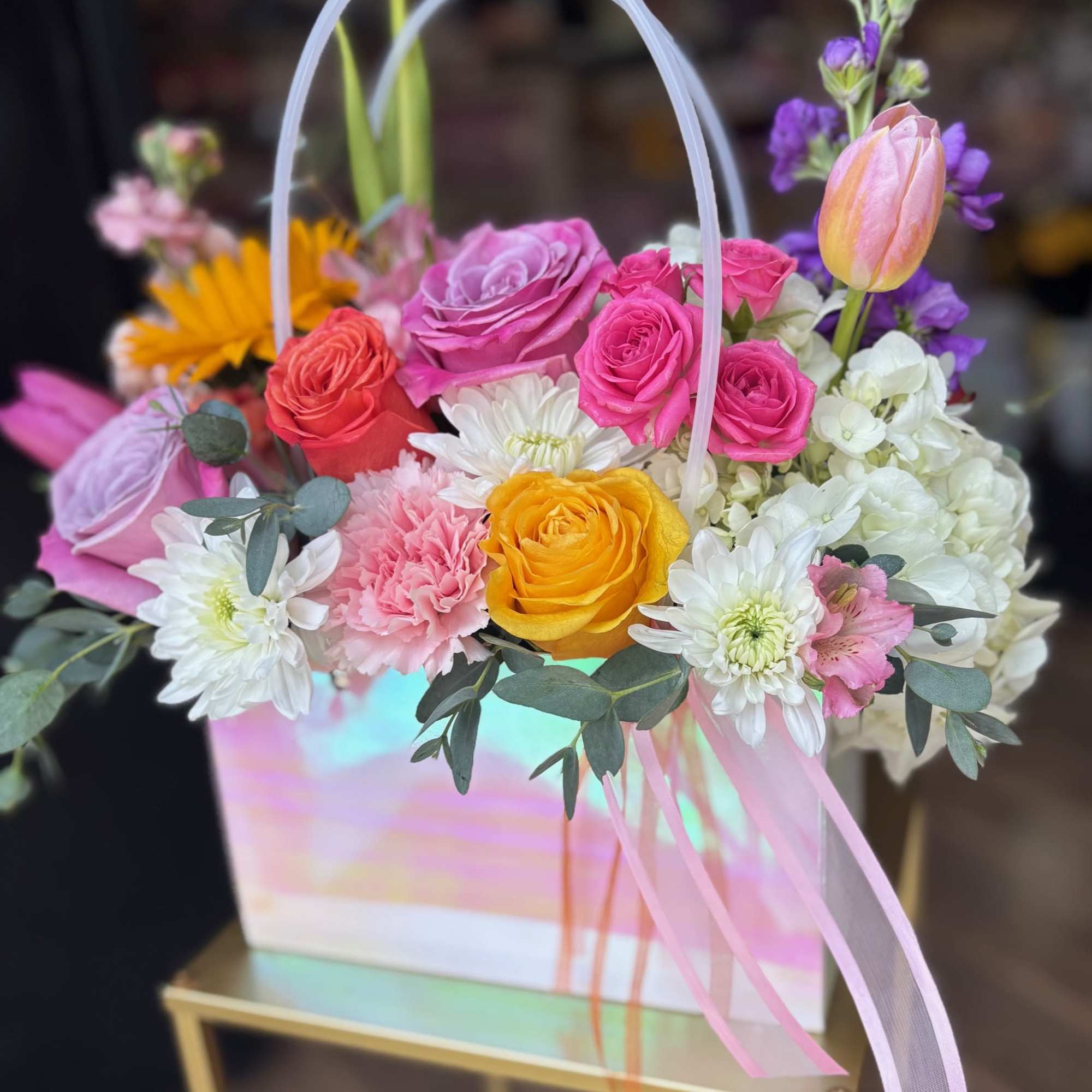 Colorful mixed flower basket with roses, tulips, and daisies