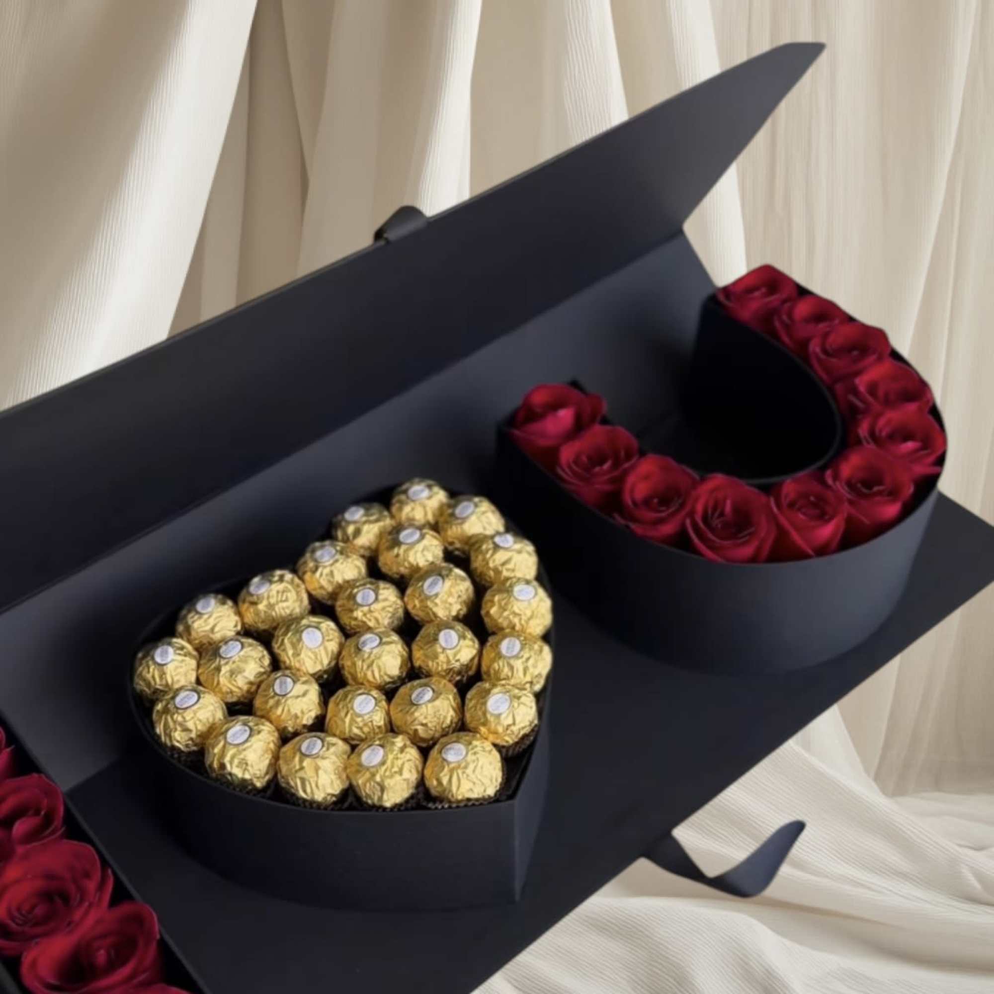 Heart-shaped box of red roses and gold-wrapped chocolates