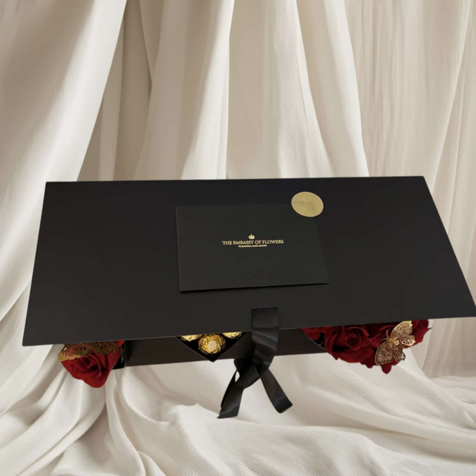 Black gift box with red roses and gold accents