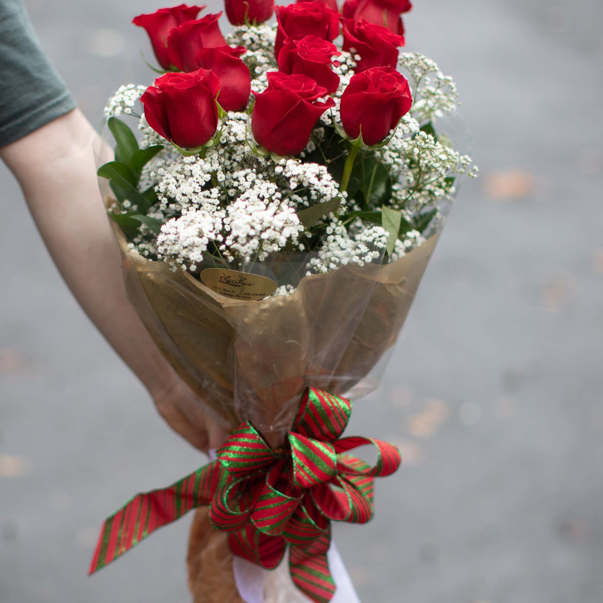 Bouquet of red roses with white baby's breath and a striped ribbon