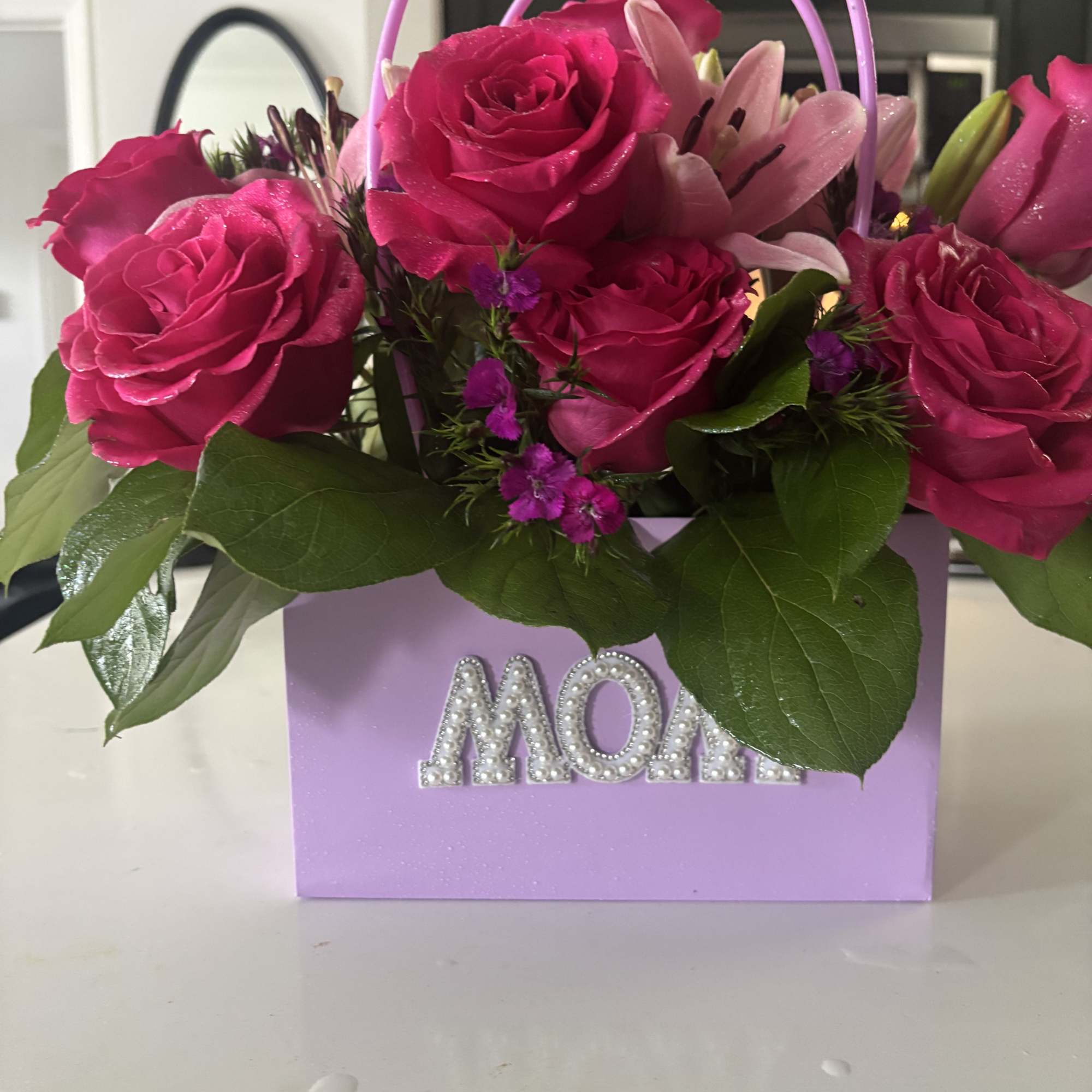 Mixed flowers in purse pouch labeled MOM. Also available with custom name