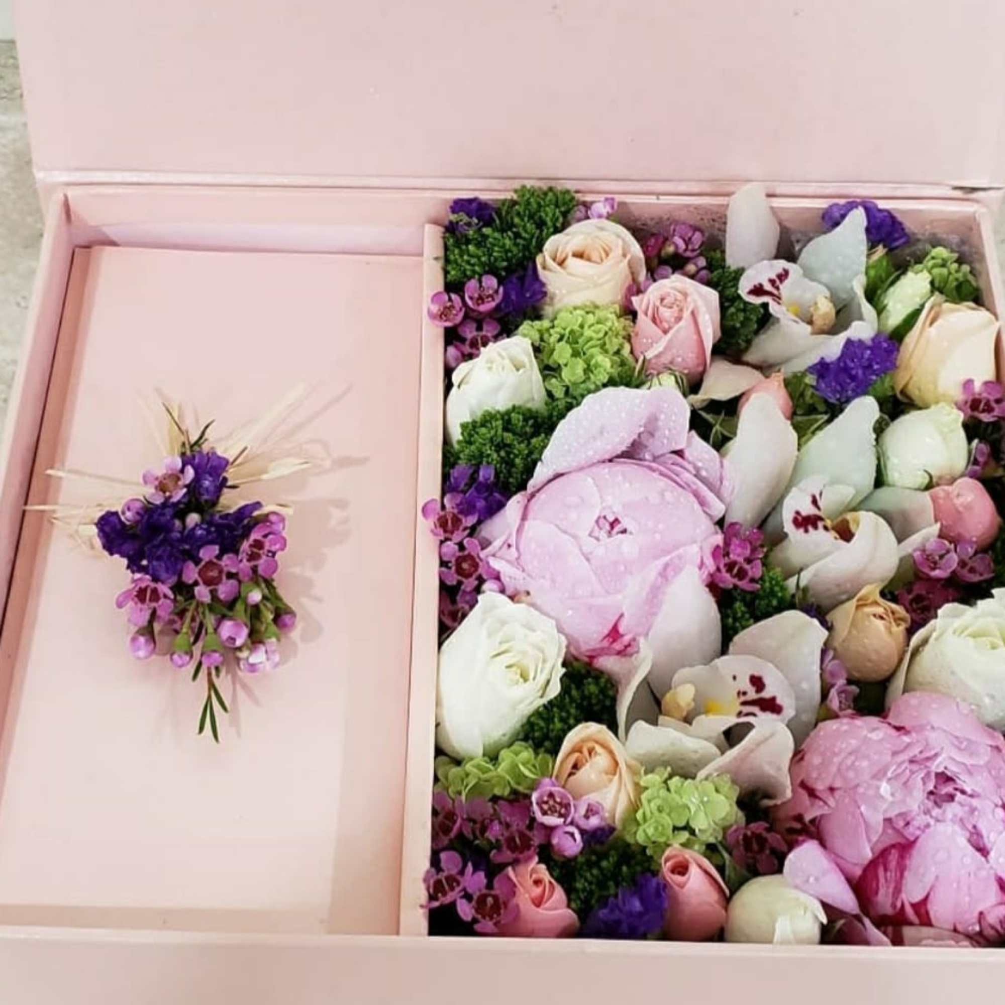 Pink gift box with a floral arrangement and matching boutonniere