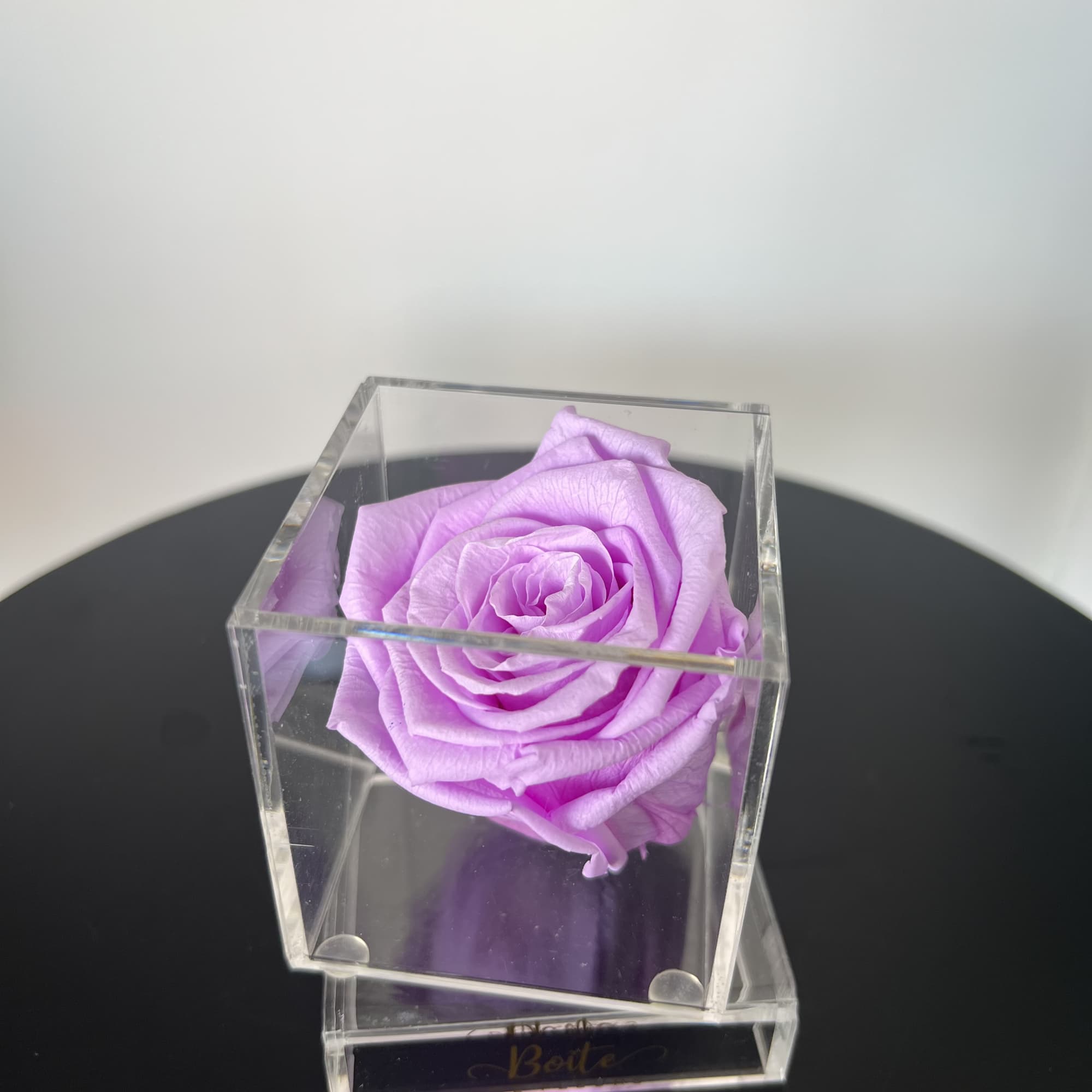 A single forever rose sits in a custom acrylic box. This petit