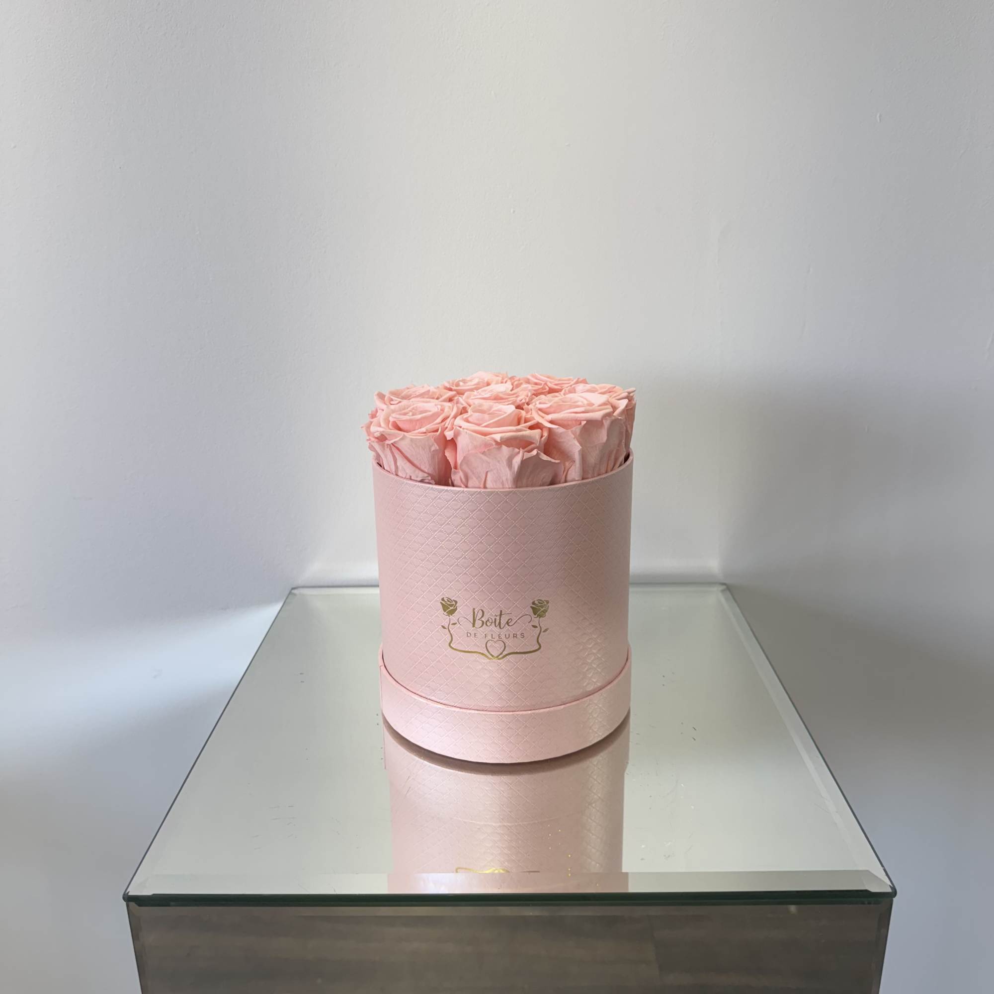 Pink roses arranged in a round pink hat box