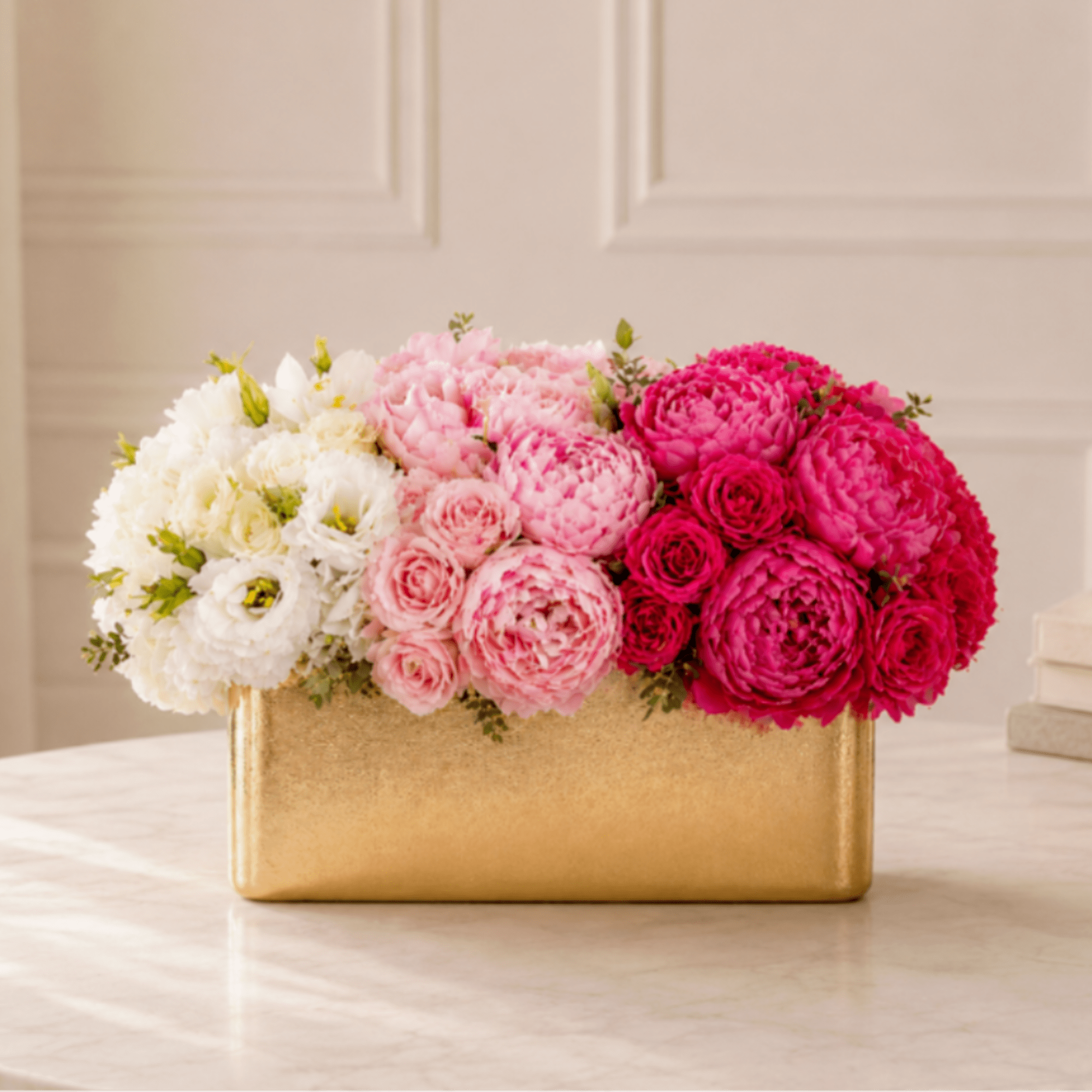 Pink and white flower arrangement in a gold rectangular box