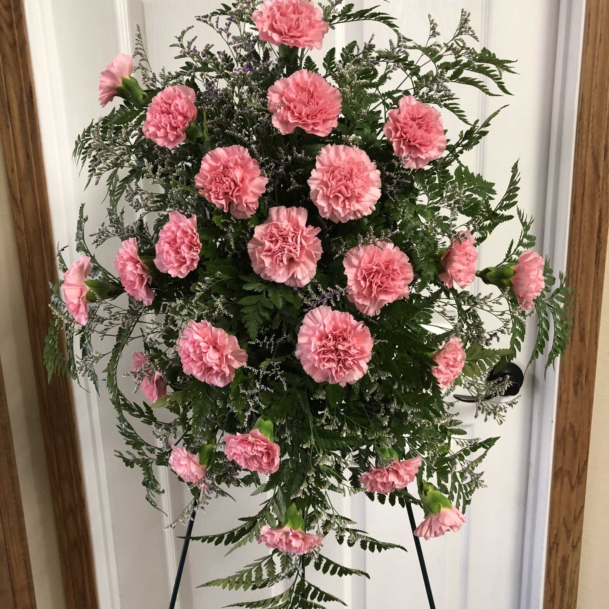 Standing pink carnation spray on an easel