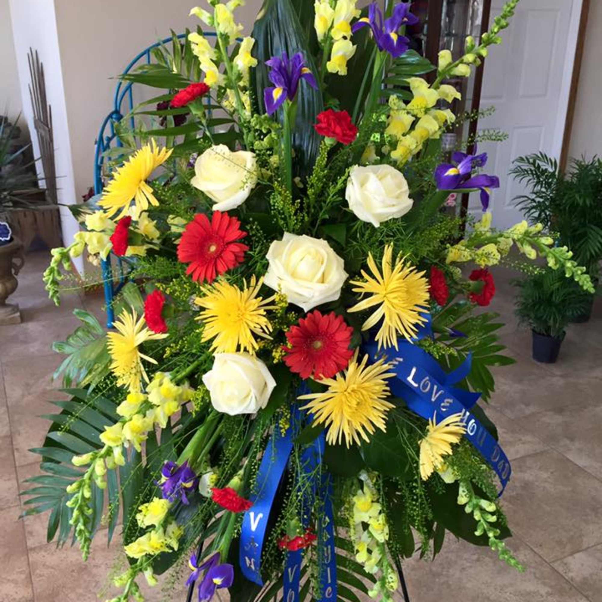 A vivid, full-standing sympathy arrangement that greets the room with warm color