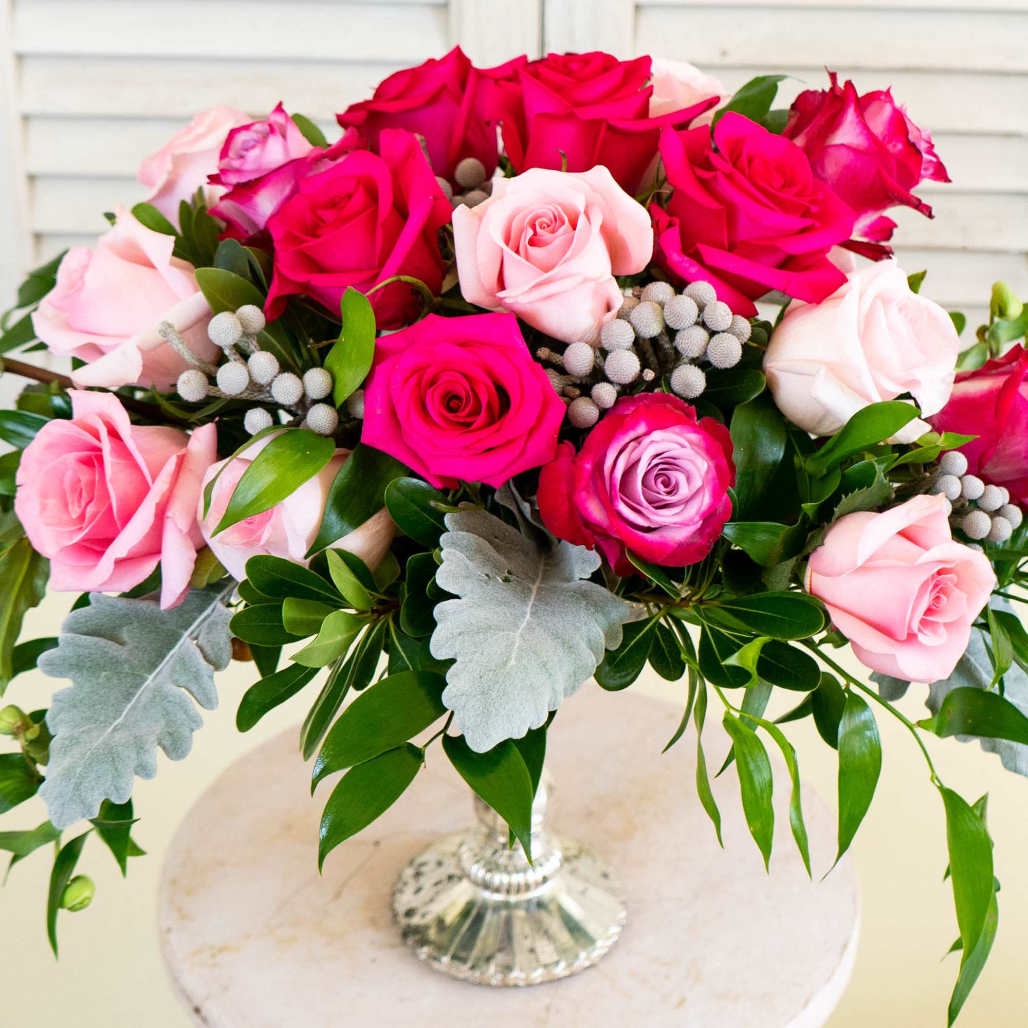 Pink and red roses arranged in a clear glass vase