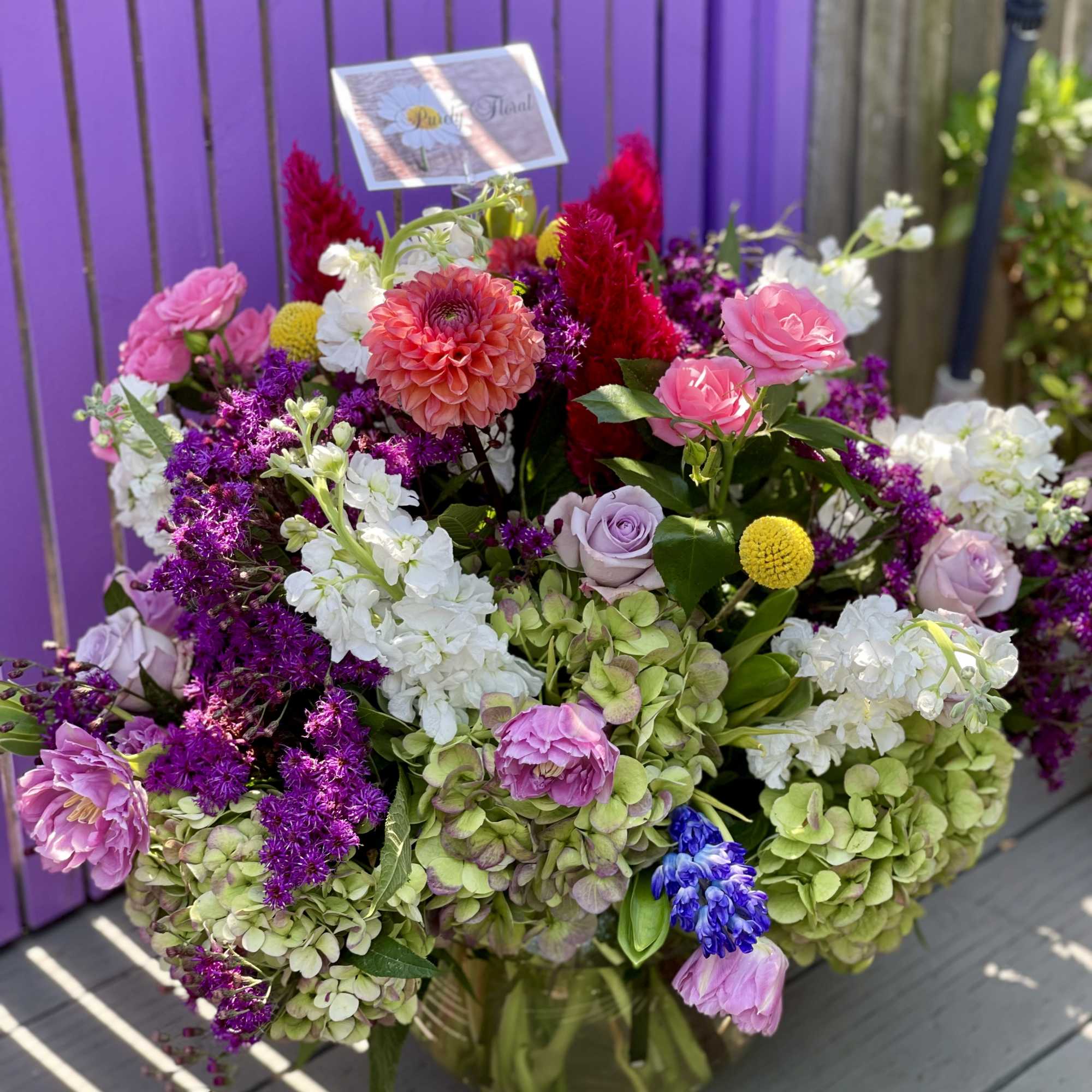Mixed bouquet in a glass vase with pink, purple, white, and yellow flowers