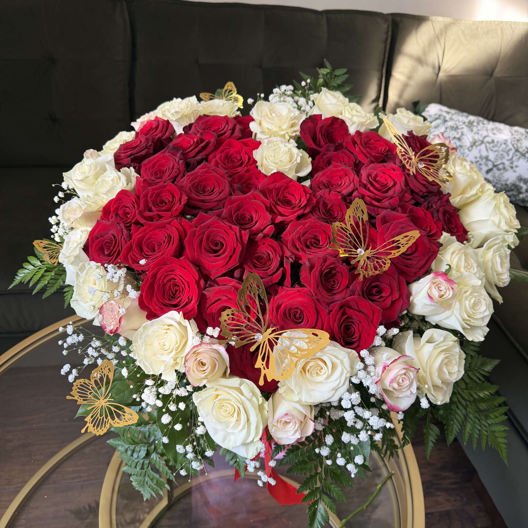 Heart-shaped bouquet of red and white roses with butterfly picks