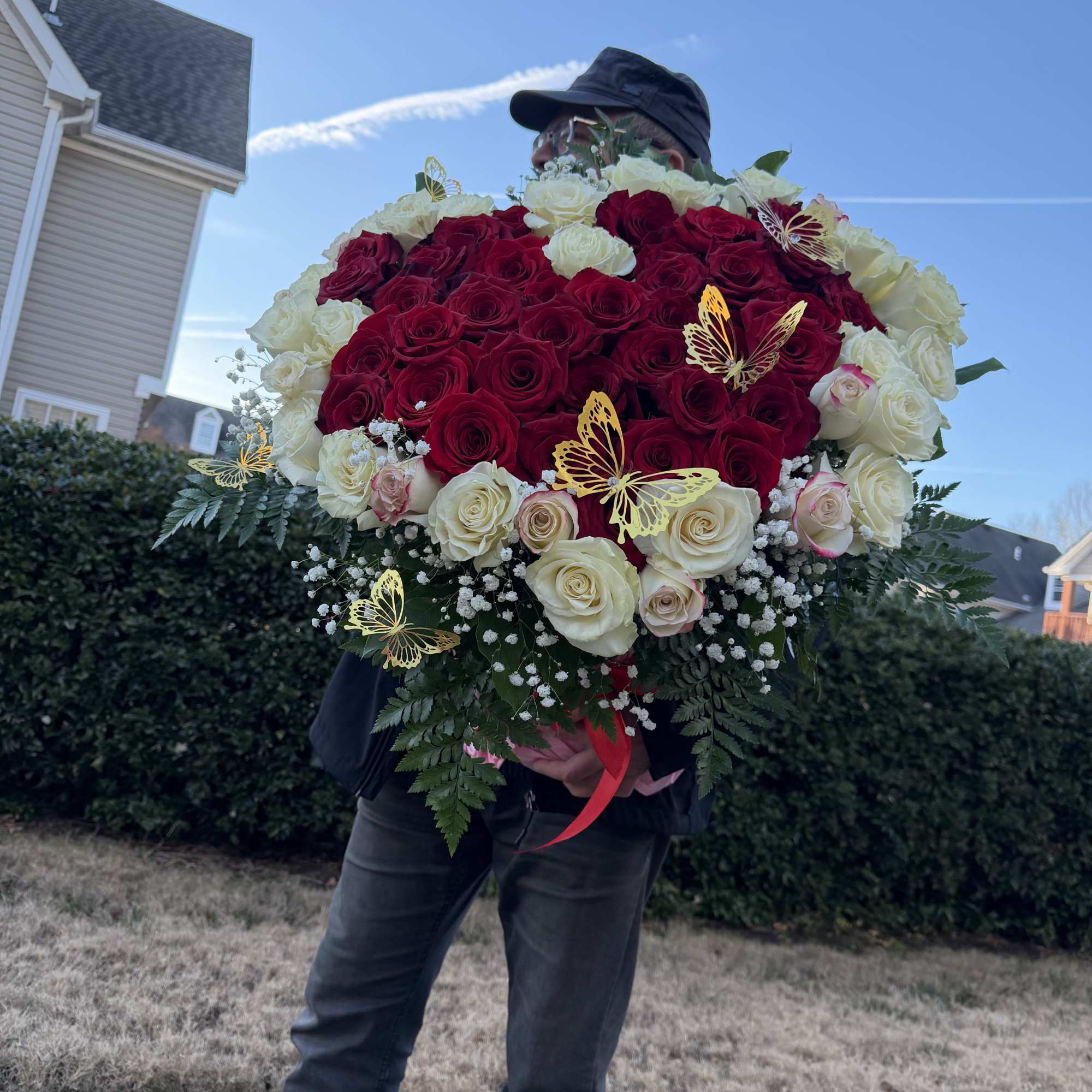 Large bouquet of red and white roses with butterfly accents