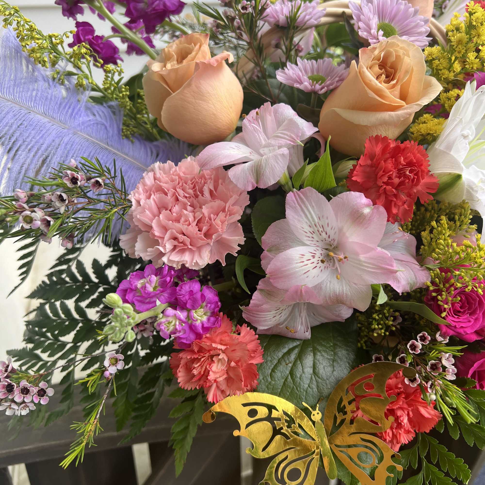 Mixed bouquet with peach roses, pink carnations, and purple blooms