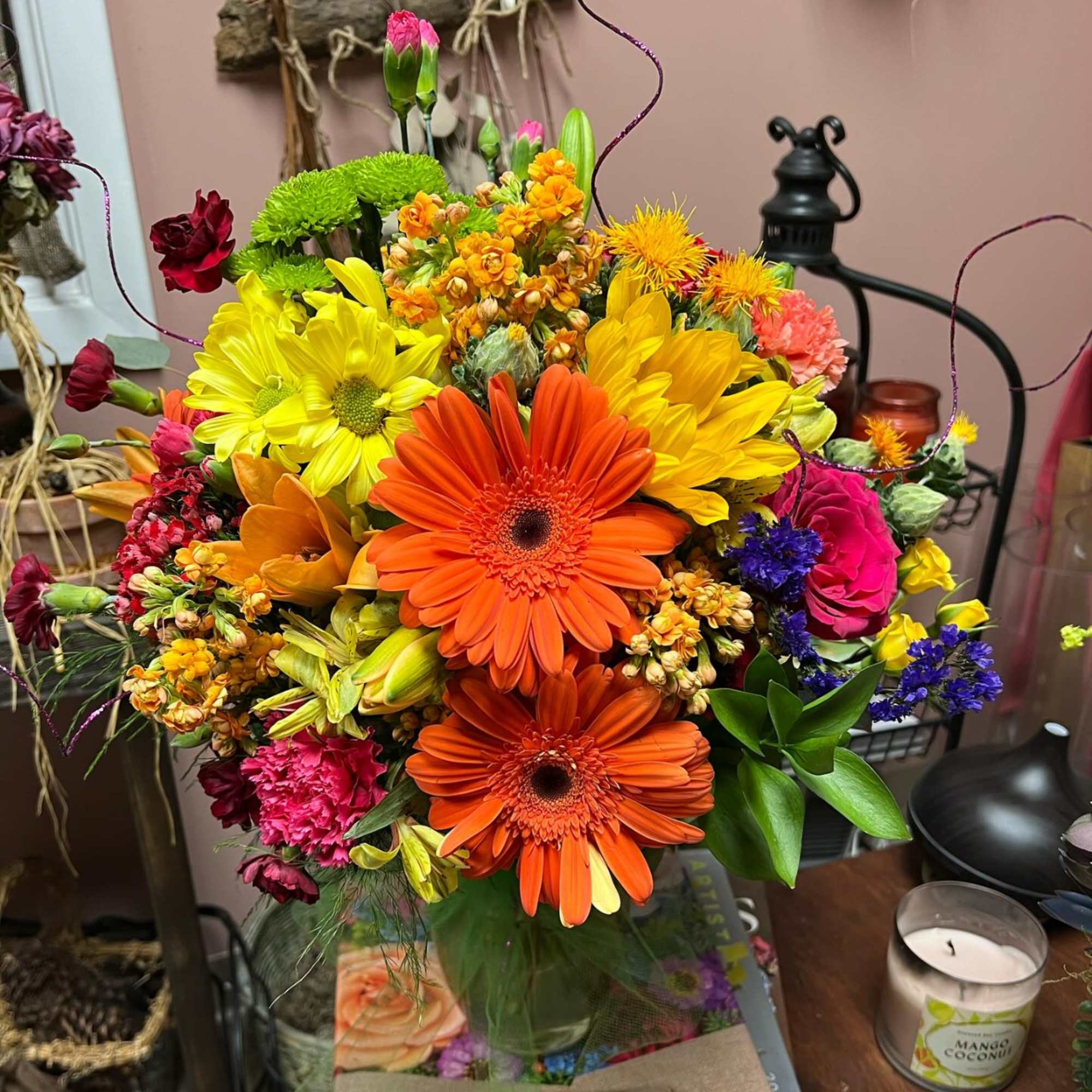 Bright mixed bouquet with orange and yellow daisies in a glass vase