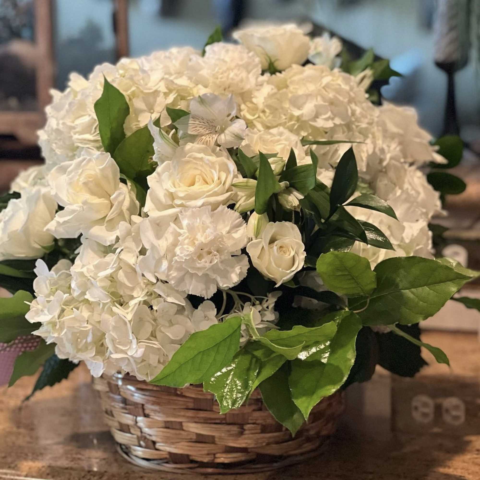 White roses and hydrangeas in a woven basket