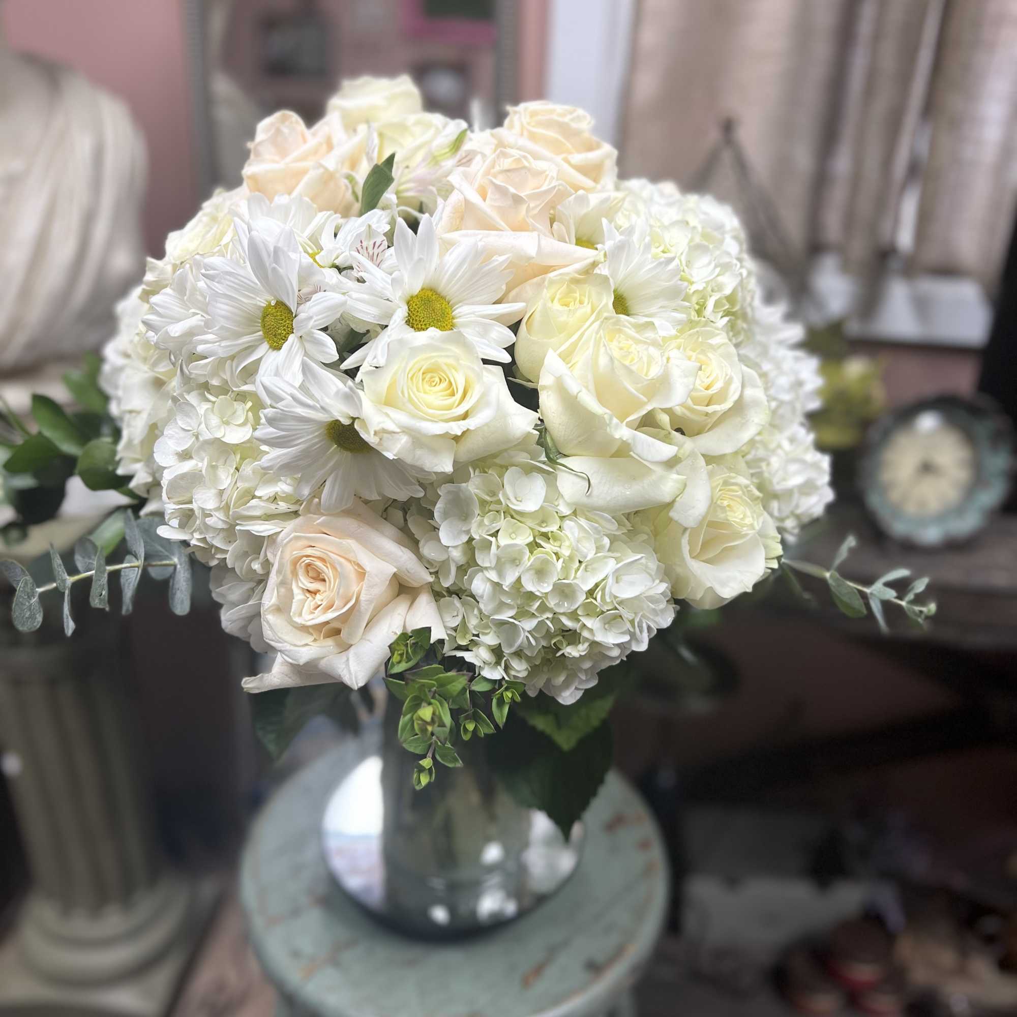 White rose and daisy bouquet in a glass vase