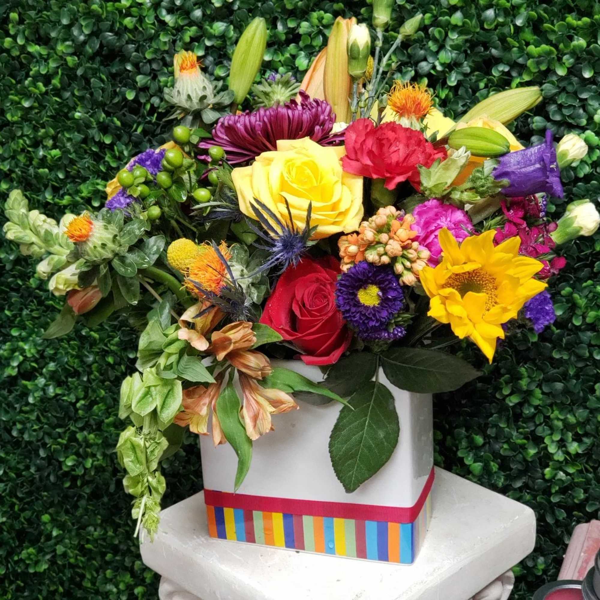 Colorful mixed flower arrangement in a white square box