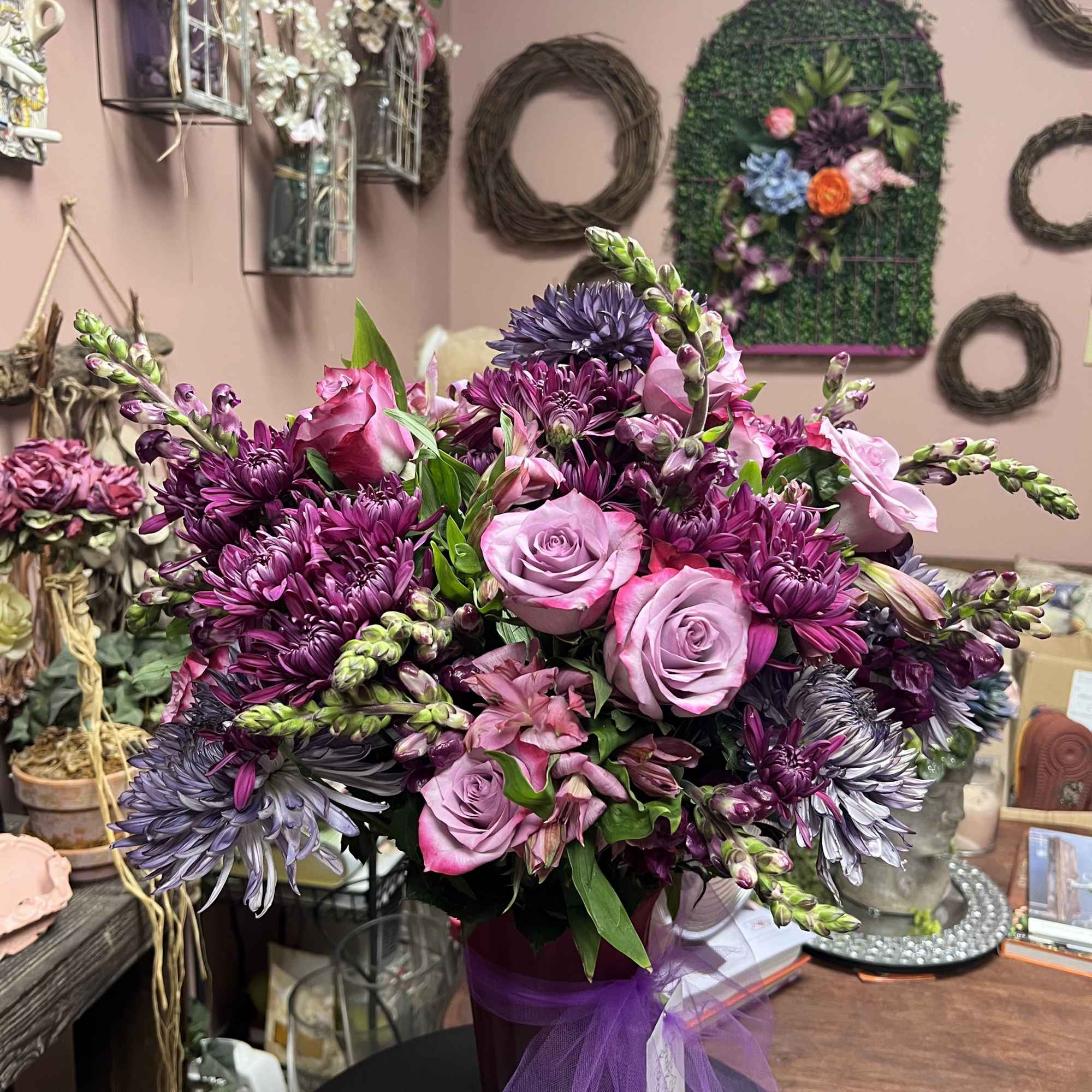 Purple and pink bouquet in a vase with a tulle ribbon