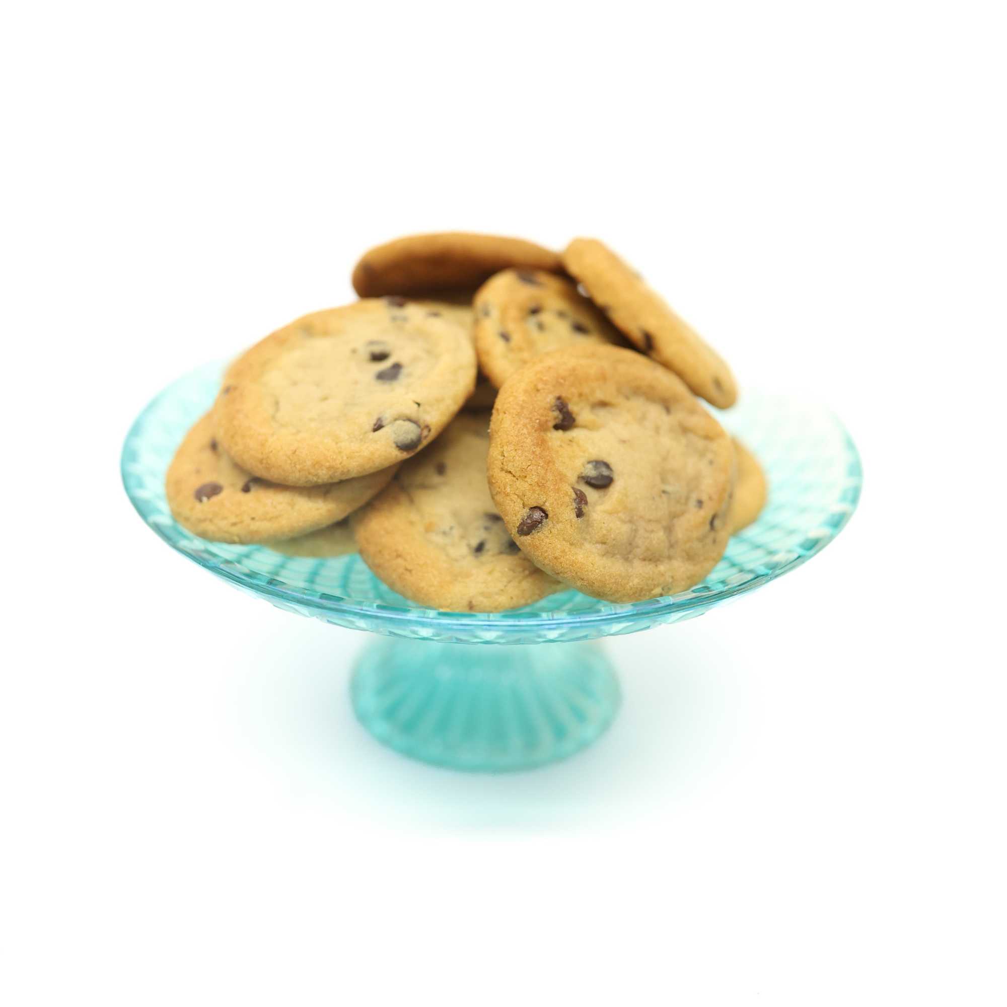 Plate of chocolate chip cookies on a turquoise glass pedestal stand