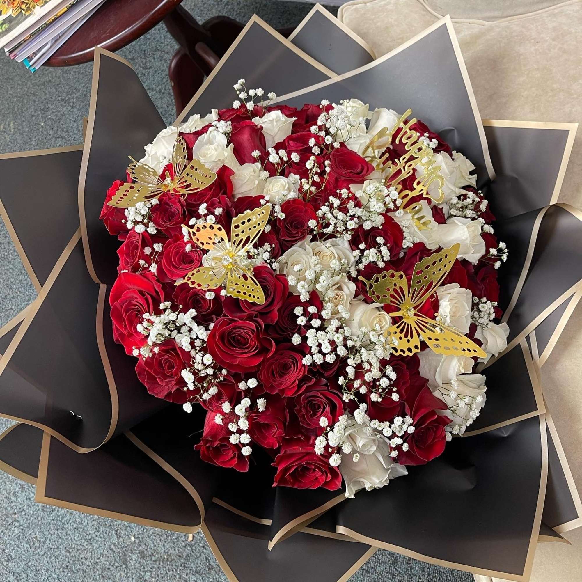 Bouquet of red and white roses with gold butterfly accents