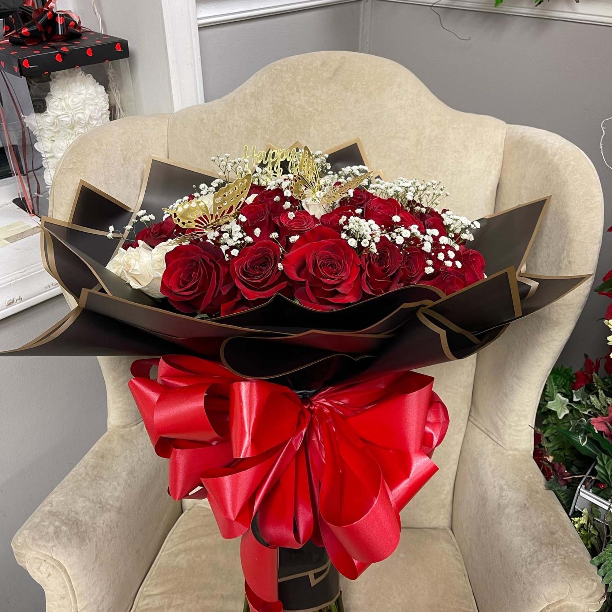 Large bouquet of red roses with white baby's breath and a red ribbon