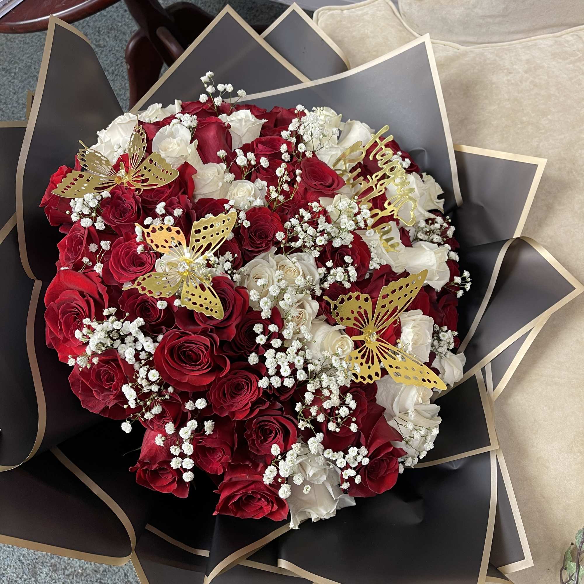 Bouquet of red and white roses with gold butterfly accents